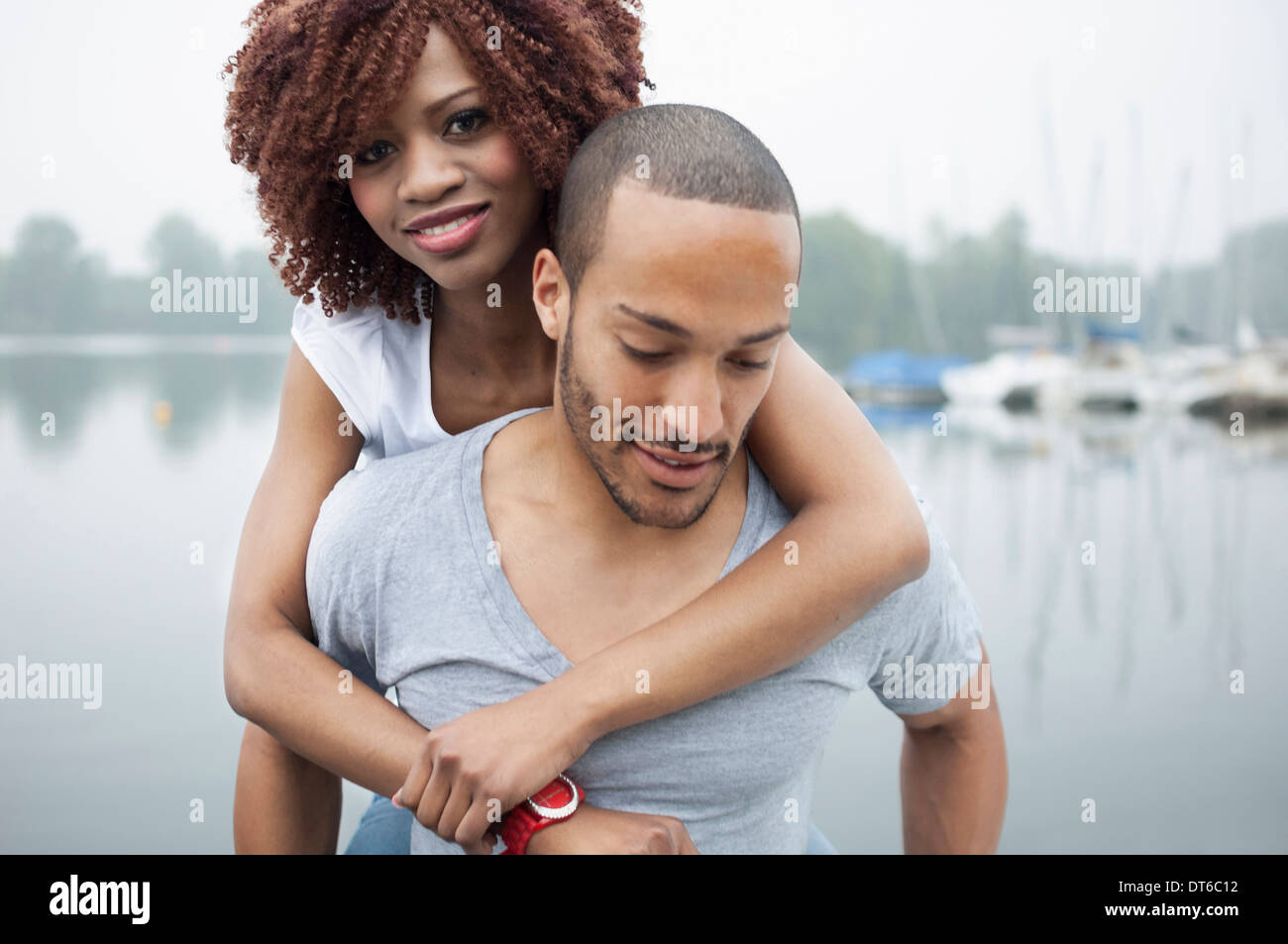 Portrait of young man giving woman piggyback Stock Photo