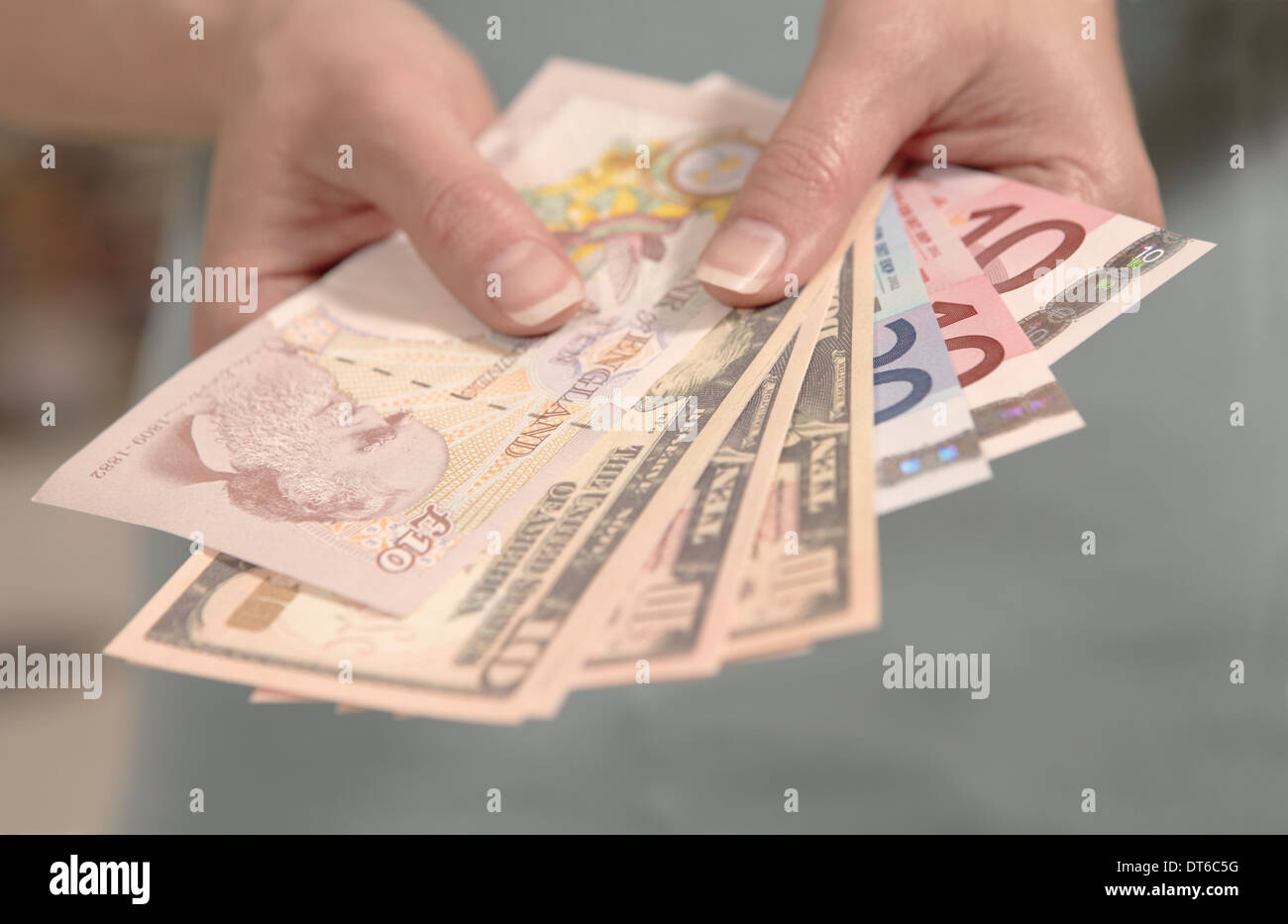 Female hands holding American, British and European currency Stock Photo