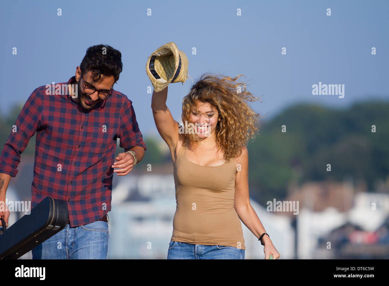 Young couple laughing, woman holding hat Stock Photo