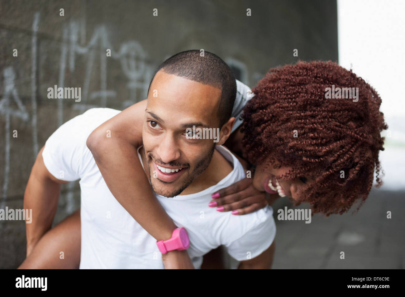 Young man giving woman piggyback Stock Photo