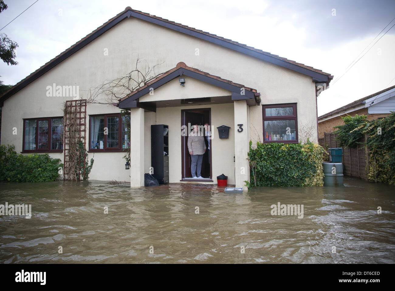 Shepperton, Greater London, UK. 9th Feb, 2014.  Christopher and Penny Holden look out of their front door onto the flooded streets in the town of Shepperton, located in the borough of Spelthorne, Greater London. Credit:  Jeff Gilbert/Alamy Live News Stock Photo