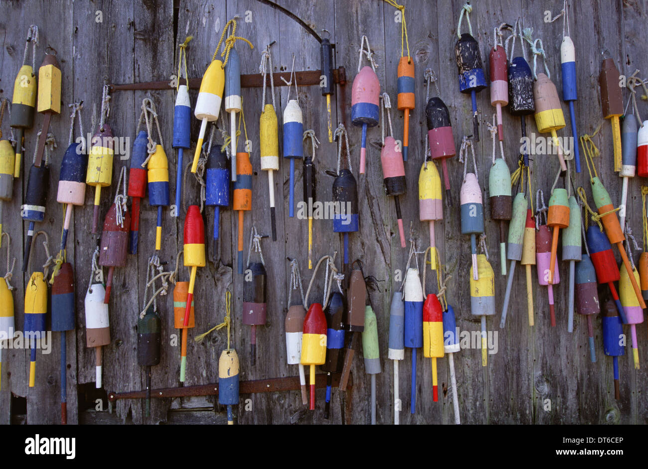 Fishing marker marine buoys or floats hanging on a fishing shed wall on the waterfront. Stock Photo
