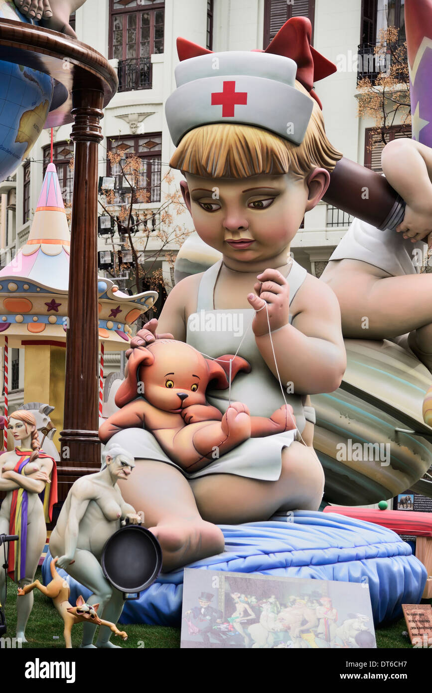 Spain, Valencia, Papier Mache figure of young girl in nurses outfit with teddy bear in the street during Las Fallas festival. Stock Photo