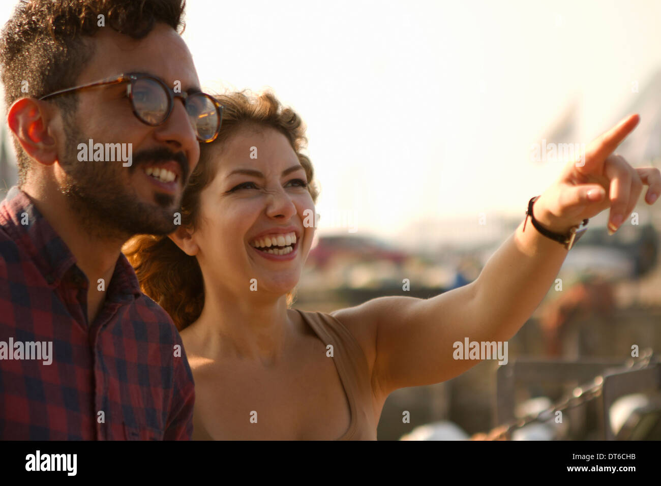 Young couple laughing, woman pointing Stock Photo