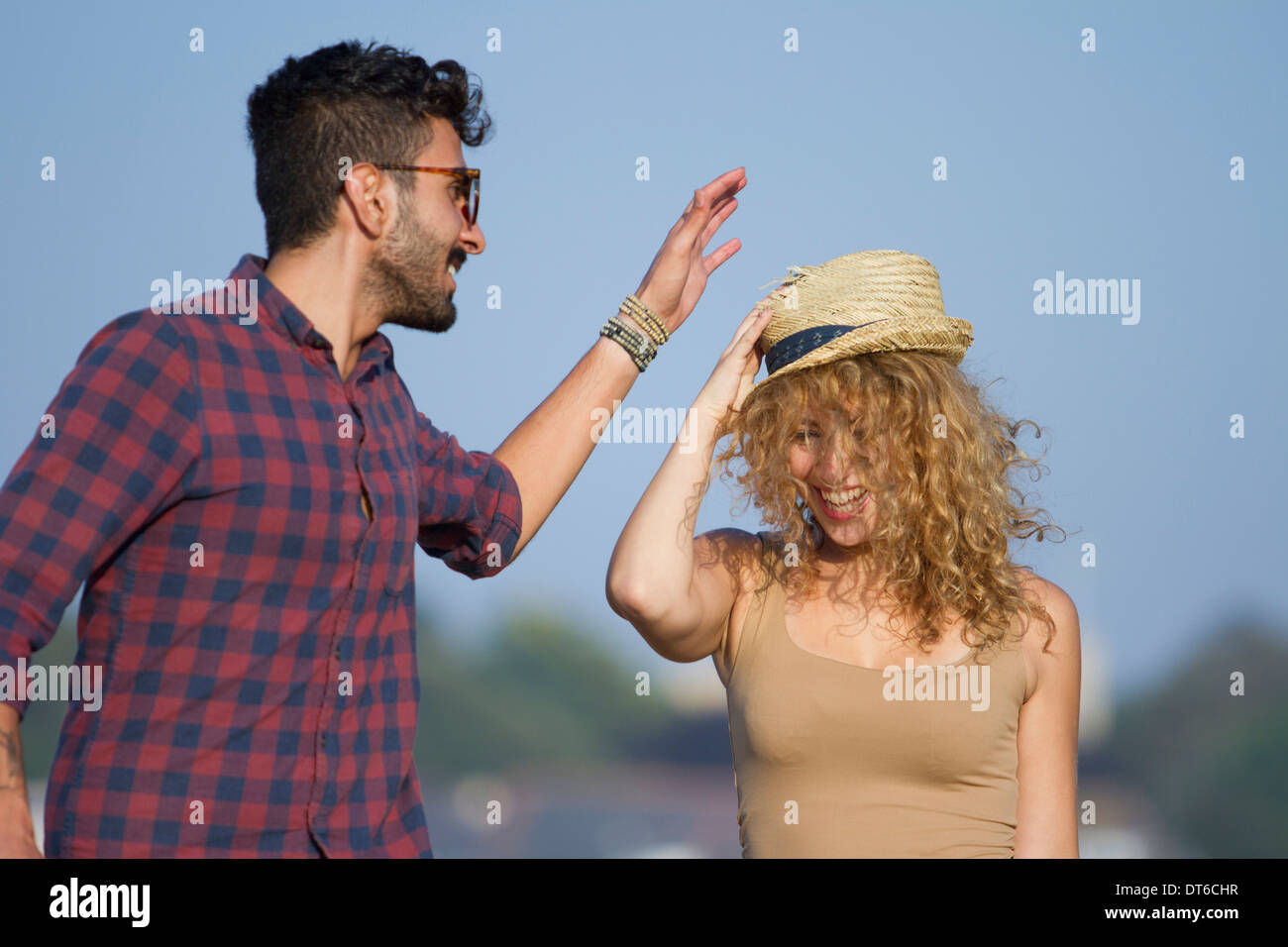 Young couple laughing, woman wearing hat Stock Photo