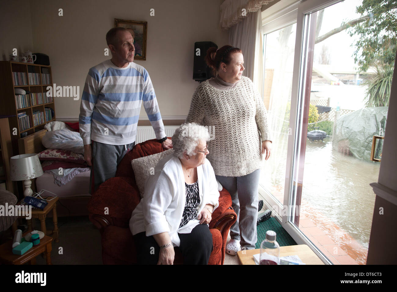 Shepperton, Greater London, UK. 9th Feb, 2014.  Margaret Yates .and her daughter Penny and husband Christopher Holden looks out onto the river banks which have broken into the flooded streets in the town of Shepperton, located in the borough of Spelthorne, Greater London, UK. Credit:  Jeff Gilbert/Alamy Live News Stock Photo