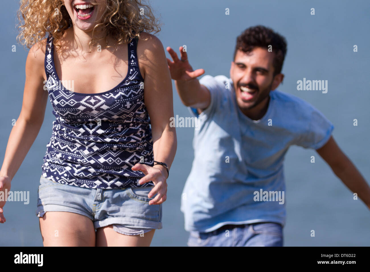 Young man chasing woman, laughing Stock Photo