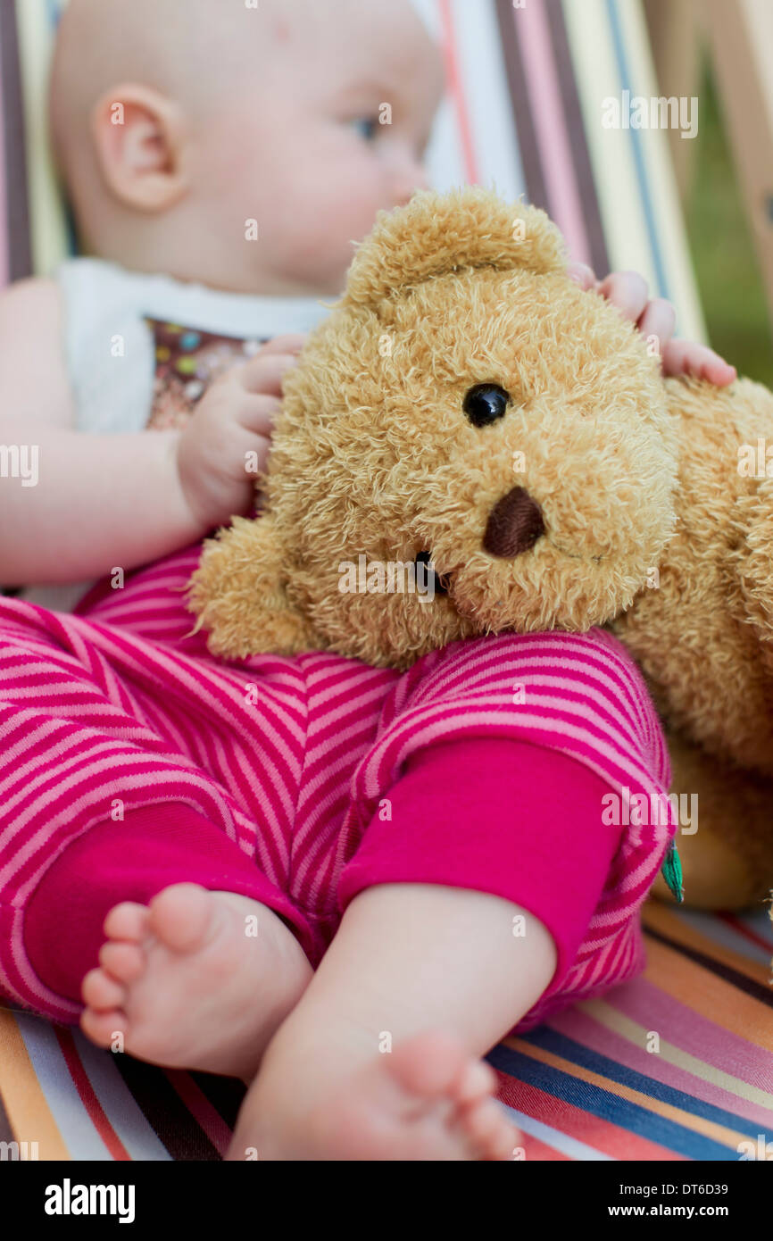Baby girl holding teddy bear Stock Photo - Alamy
