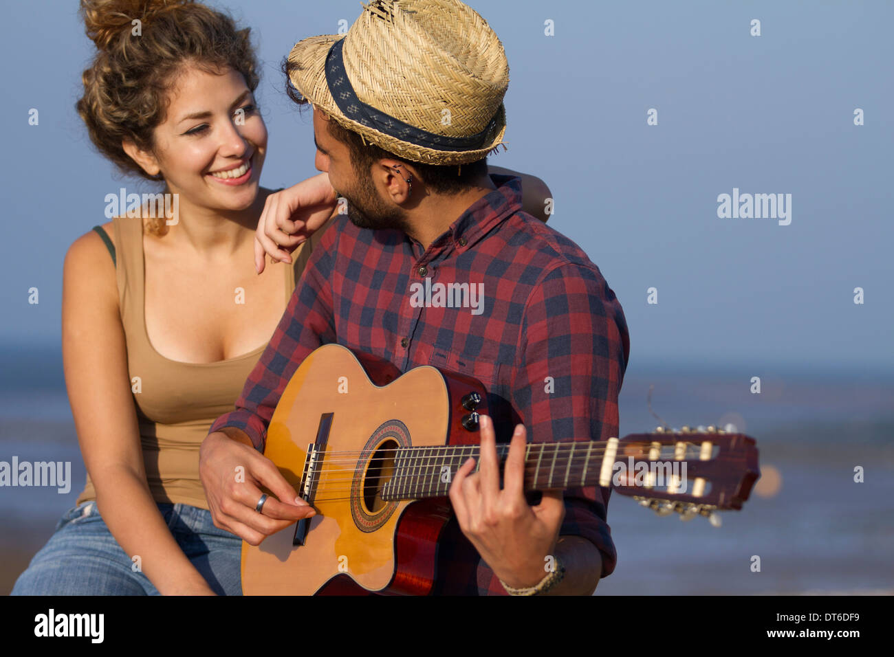 Young couple, man playing guitar Stock Photo