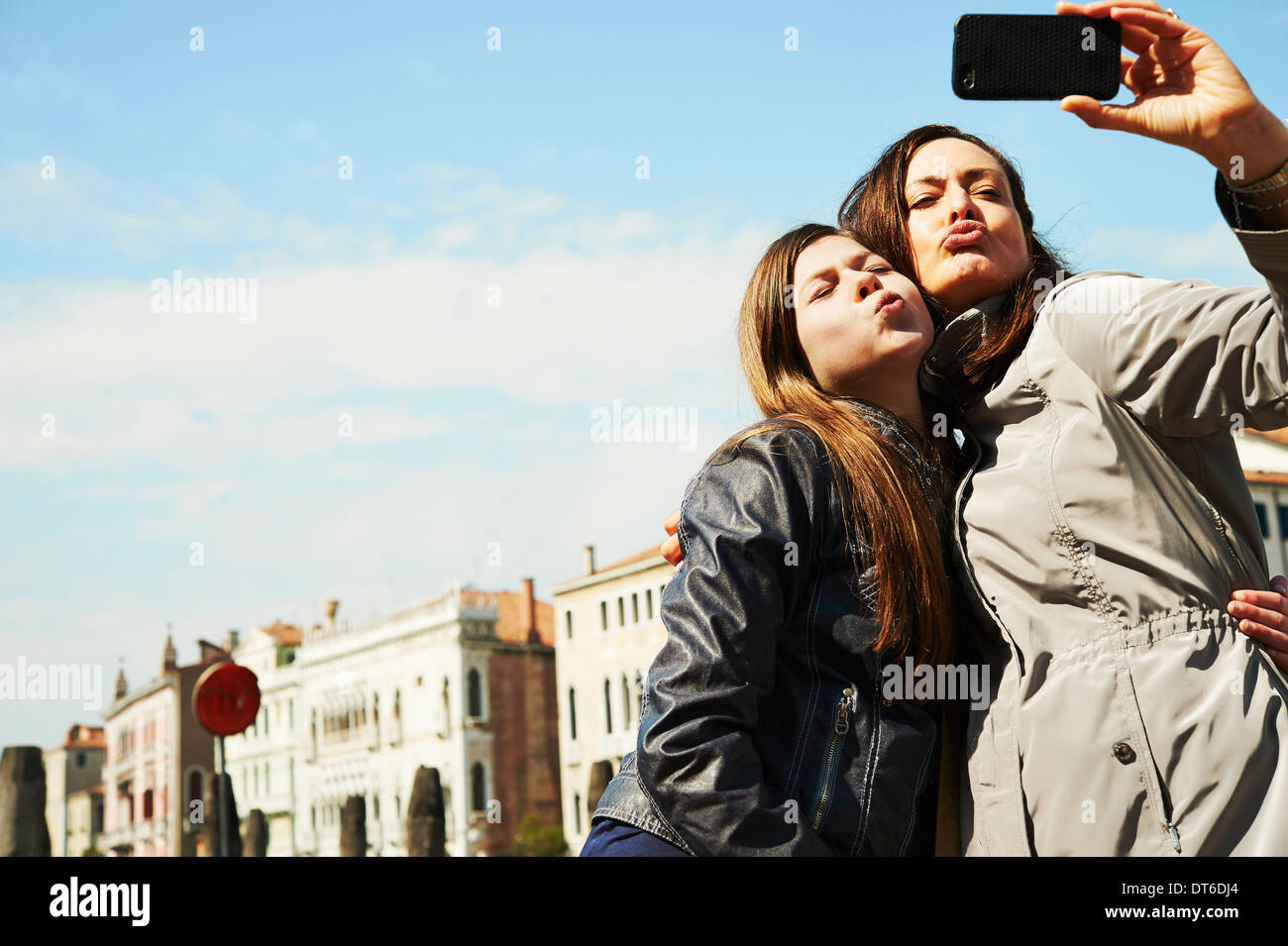 Mother and daughter taking selfie on smartphone, Venice, Italy Stock Photo