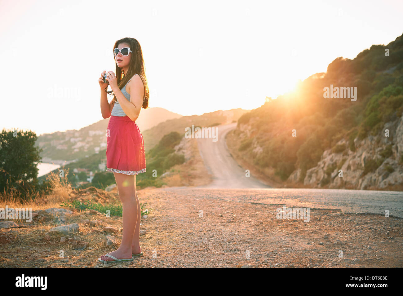 Girl holding camera at sunset, Kas, Turkey Stock Photo
