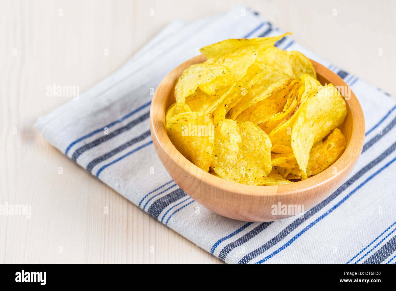 Potato chips in a white ceramic bowl on the table Stock Photo