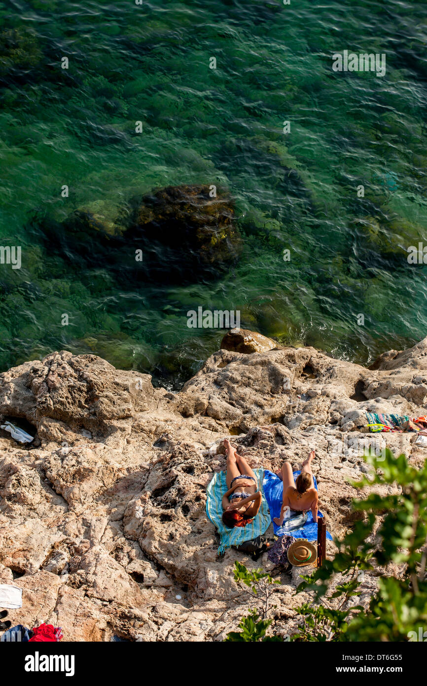 Sunbathing on the rocks typical of the Adriatic Sea Stock Photo