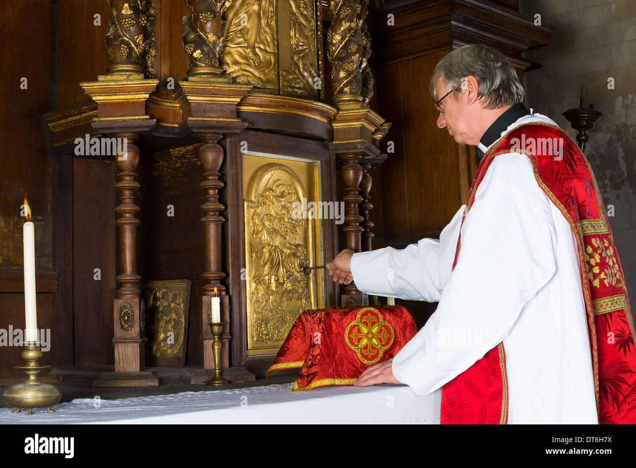 Baroque antique tabernacle with priest returning the chalice after holy mass in a medieval church Stock Photo