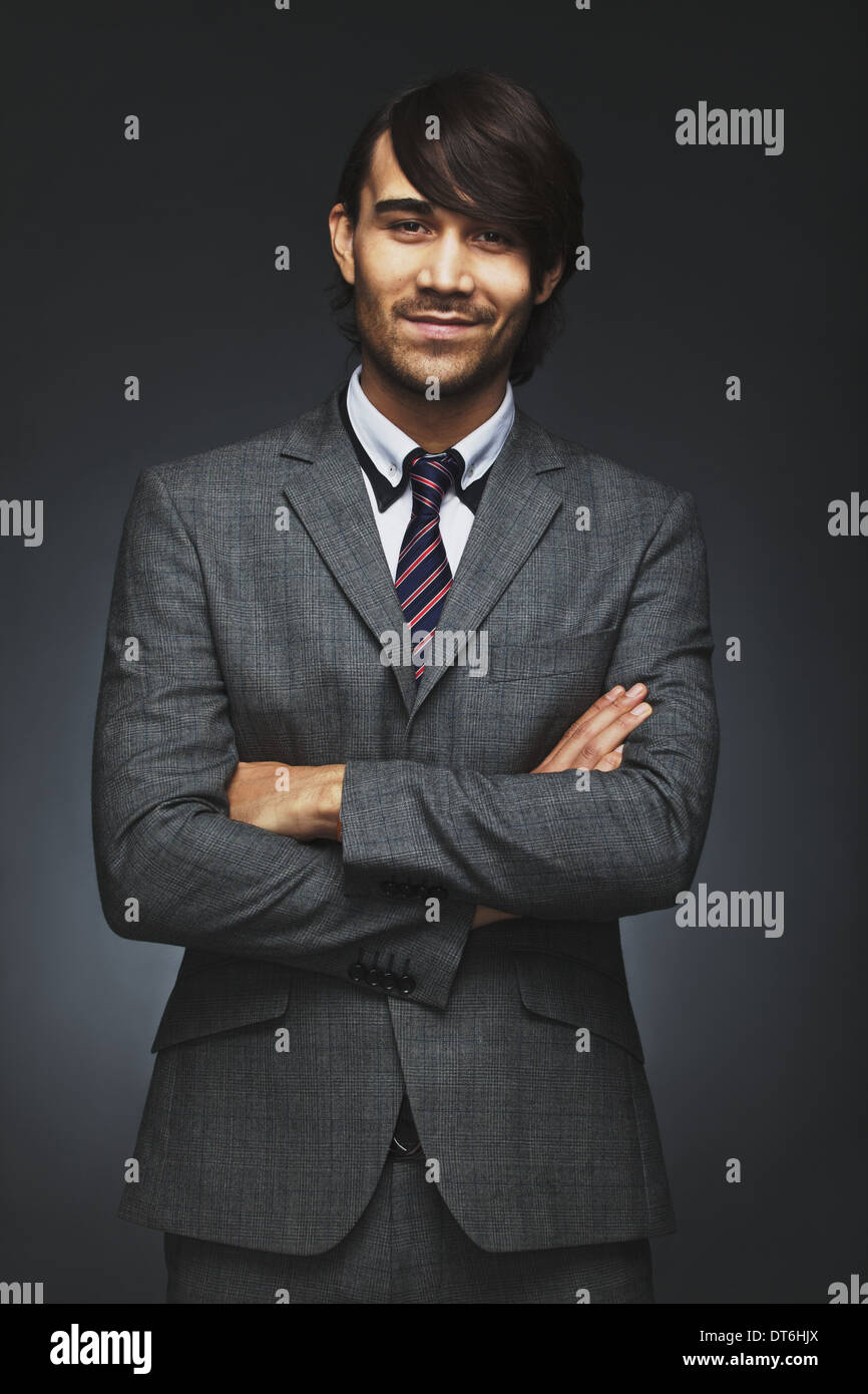 Portrait of happy young businessman smiling with his arms crossed ...