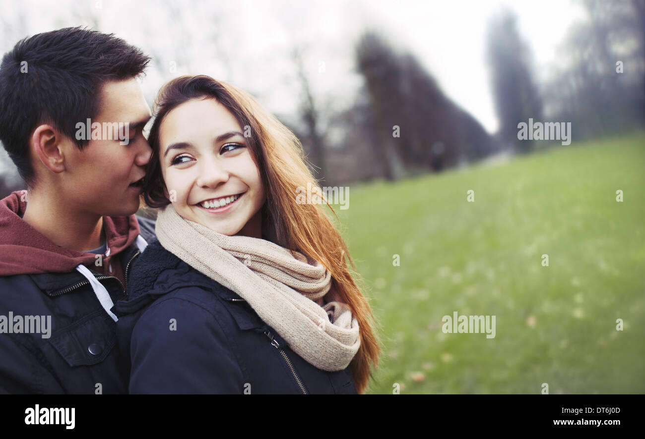 Cute young couple enjoying each others company. Teenage man and woman outdoors in park with copyspace. Stock Photo