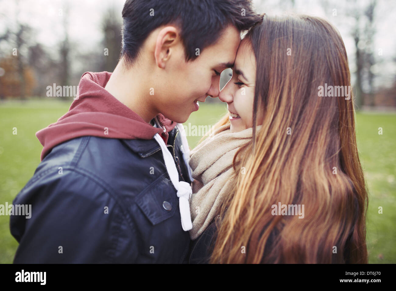 Close up of cute teenage couple in love sharing a special moment. Romantic young man and woman outdoors in park. Stock Photo