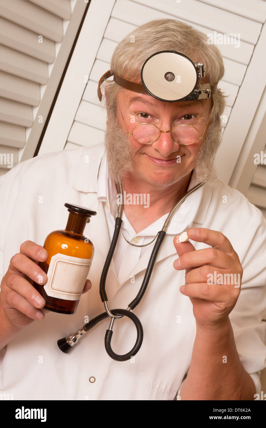 Vintage doctor telling the patient to open his mouth for a big pill Stock Photo