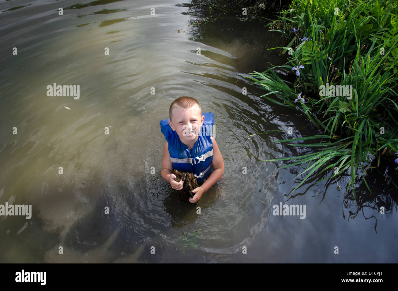 young boy wearing life jacket swimming in pond Stock Photo Alamy