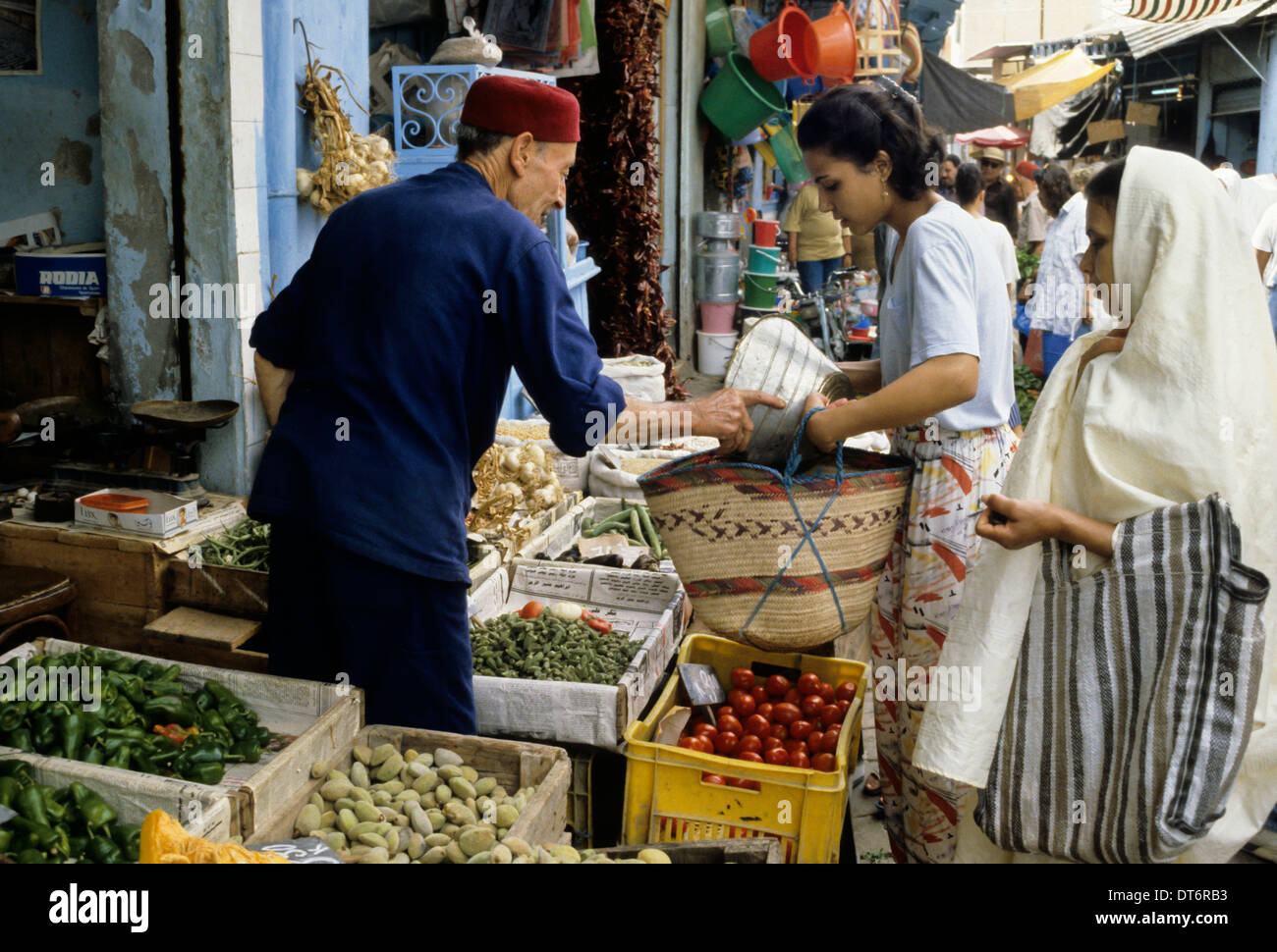 Tunis, Tunisia. Vegetable Vendor. Tunisian Women Wearing Modern and Traditional Styles of Dress. Stock Photo