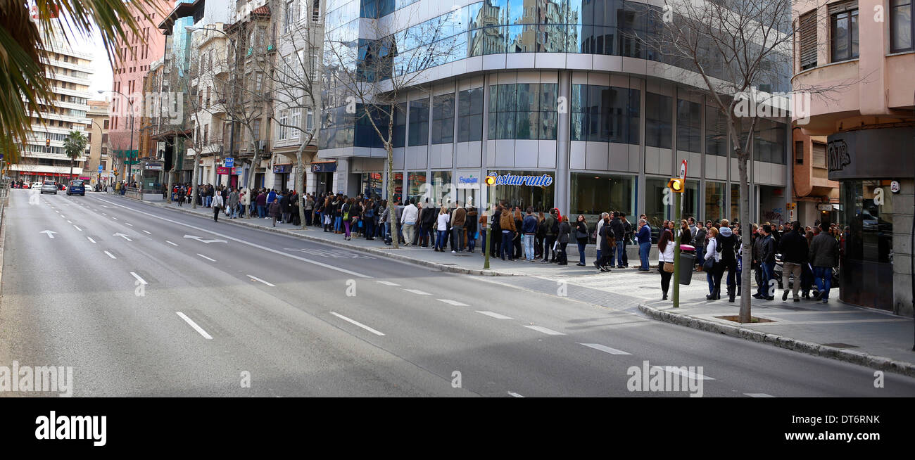 People await in queue their turn to apply for a job offer in the island of Mallorca, Spain Stock Photo