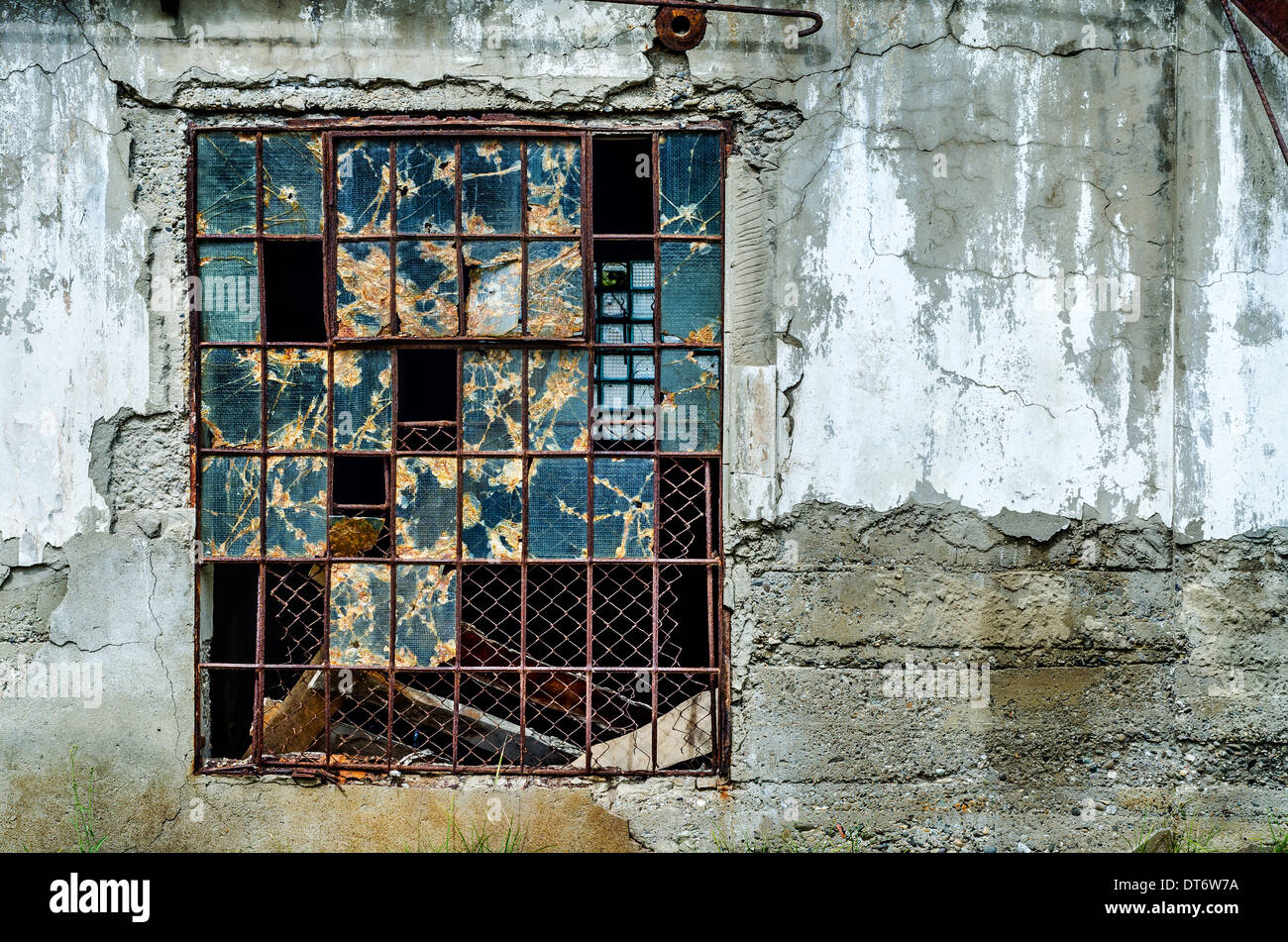 Old broken window in gray concrete wall Stock Photo
