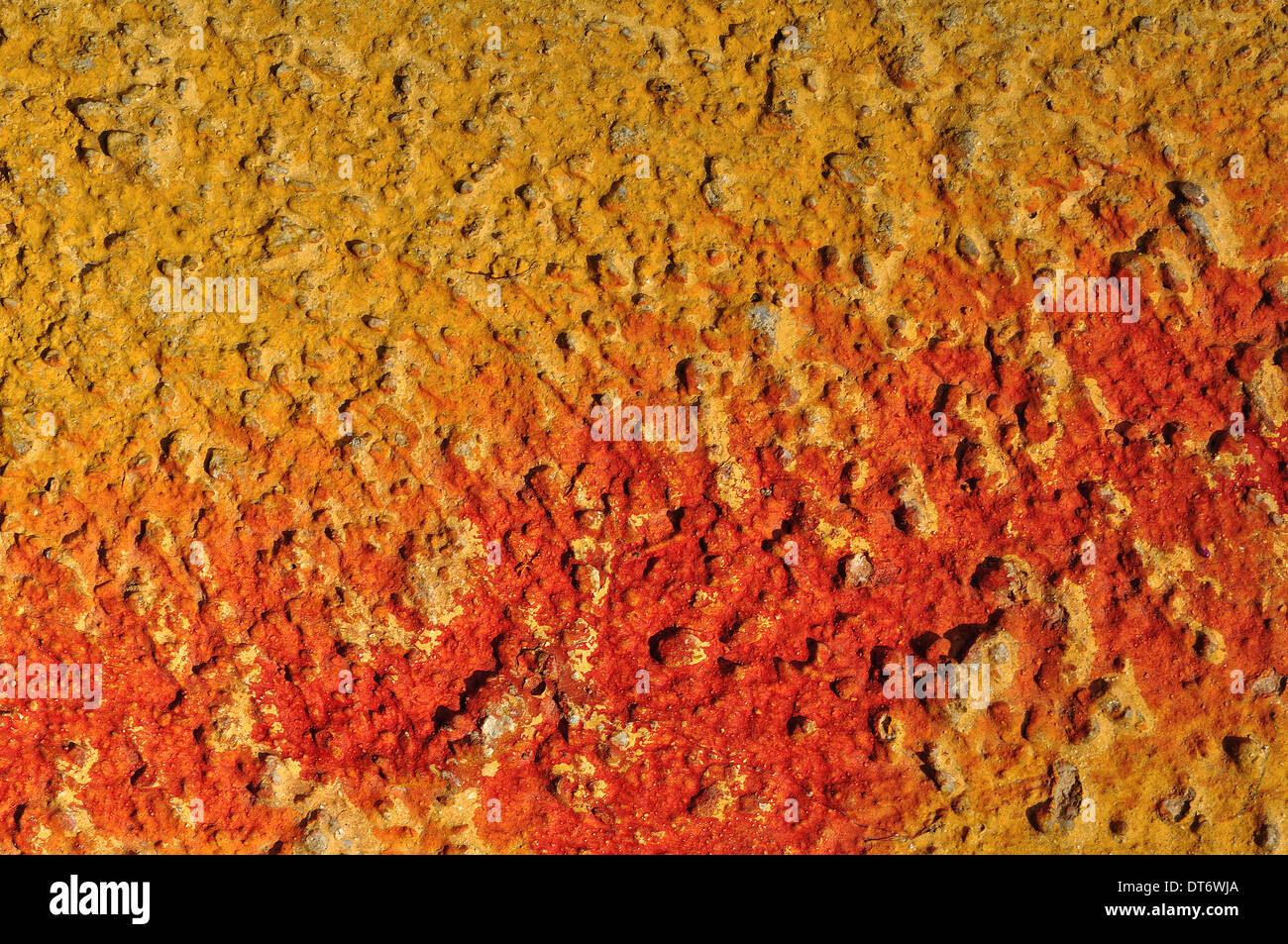 Red paint smudged on yellow textured wall background. Stock Photo