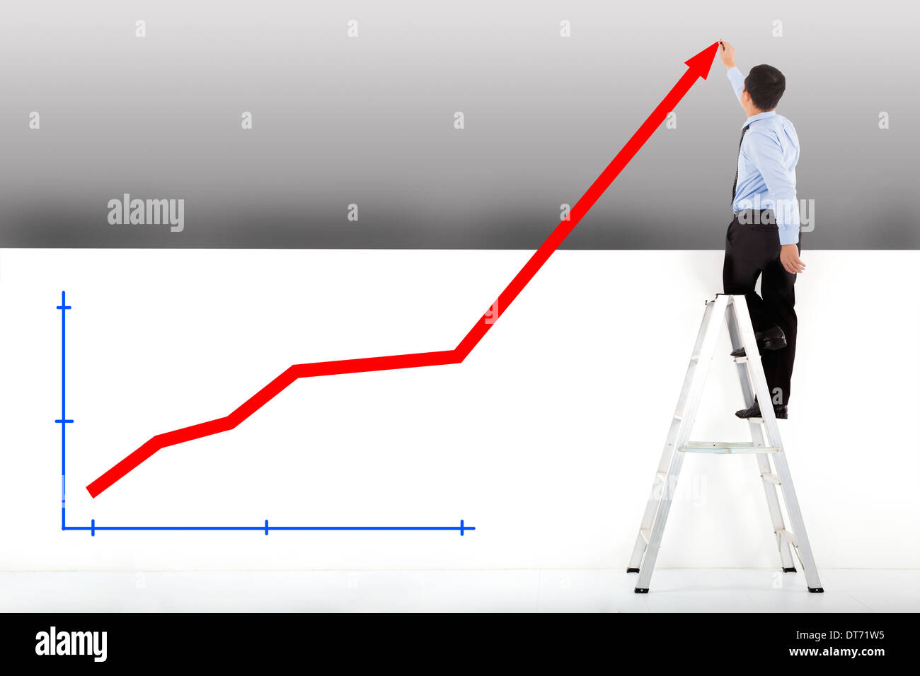 businessman standing on ladder drawing diagrams Stock Photo