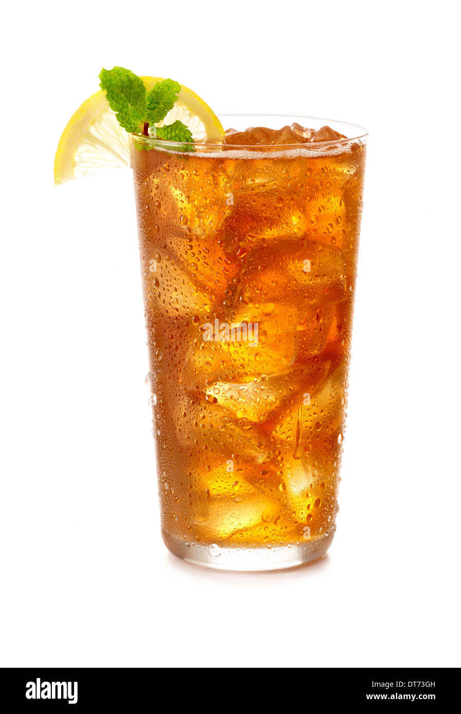 A cold glass of iced tea with a lemon wedge garnish and a sprig of mint in a clear glass with icecubes Stock Photo