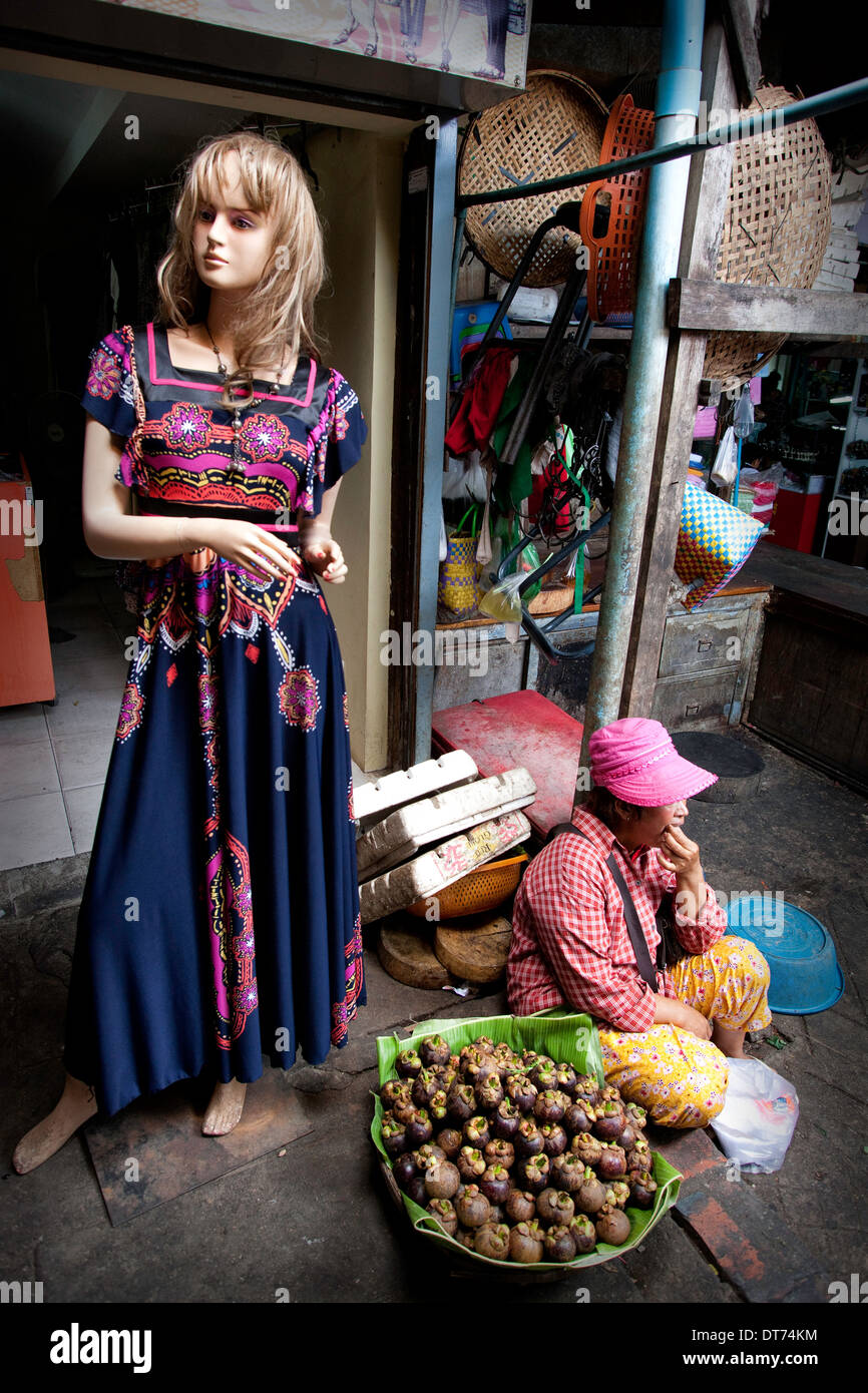 A female mannequin standing next to a market vendor in Cambodia Stock