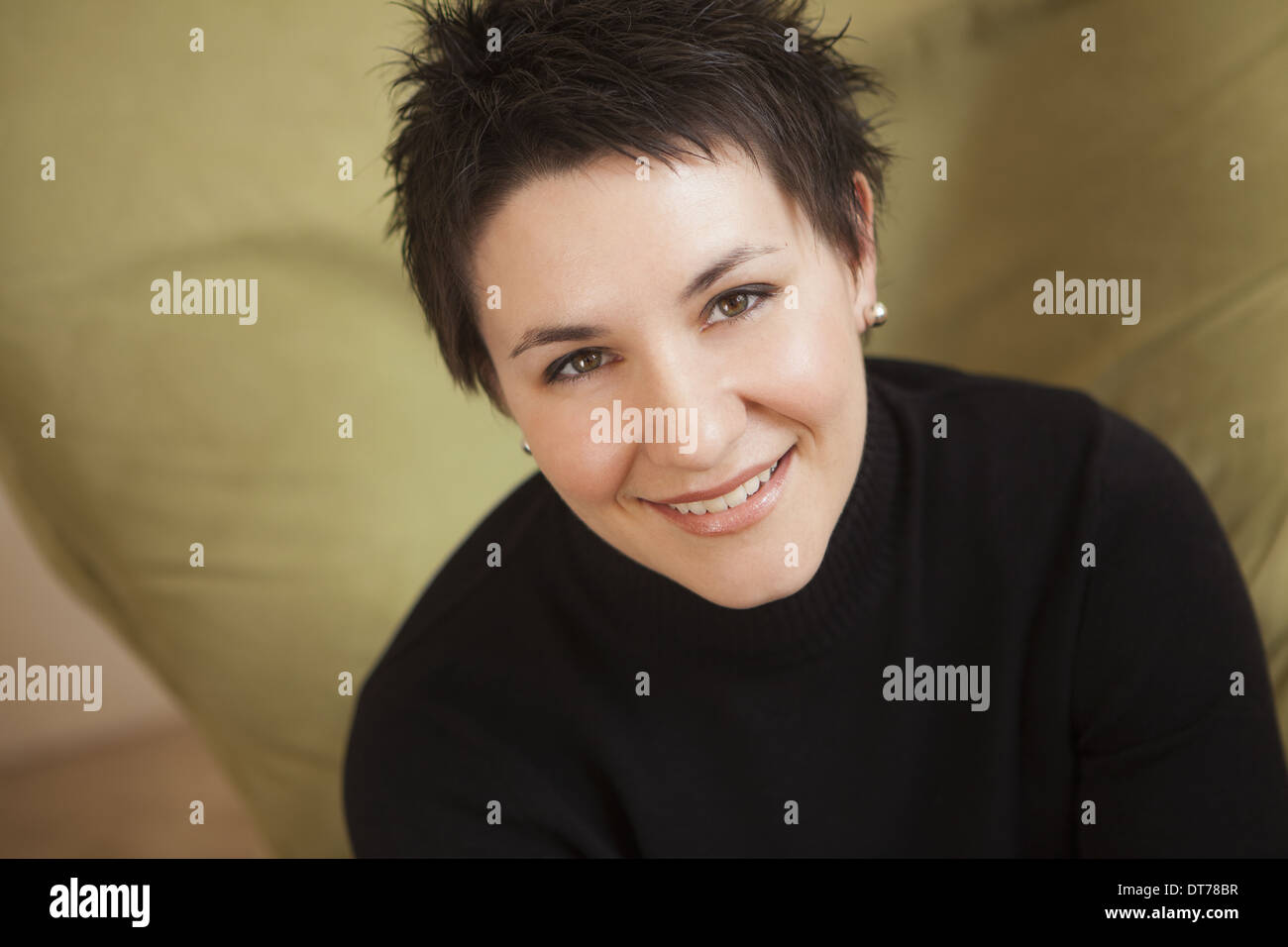 A Woman With Short Spiky Brown Hair Wearing A Black Turtleneck