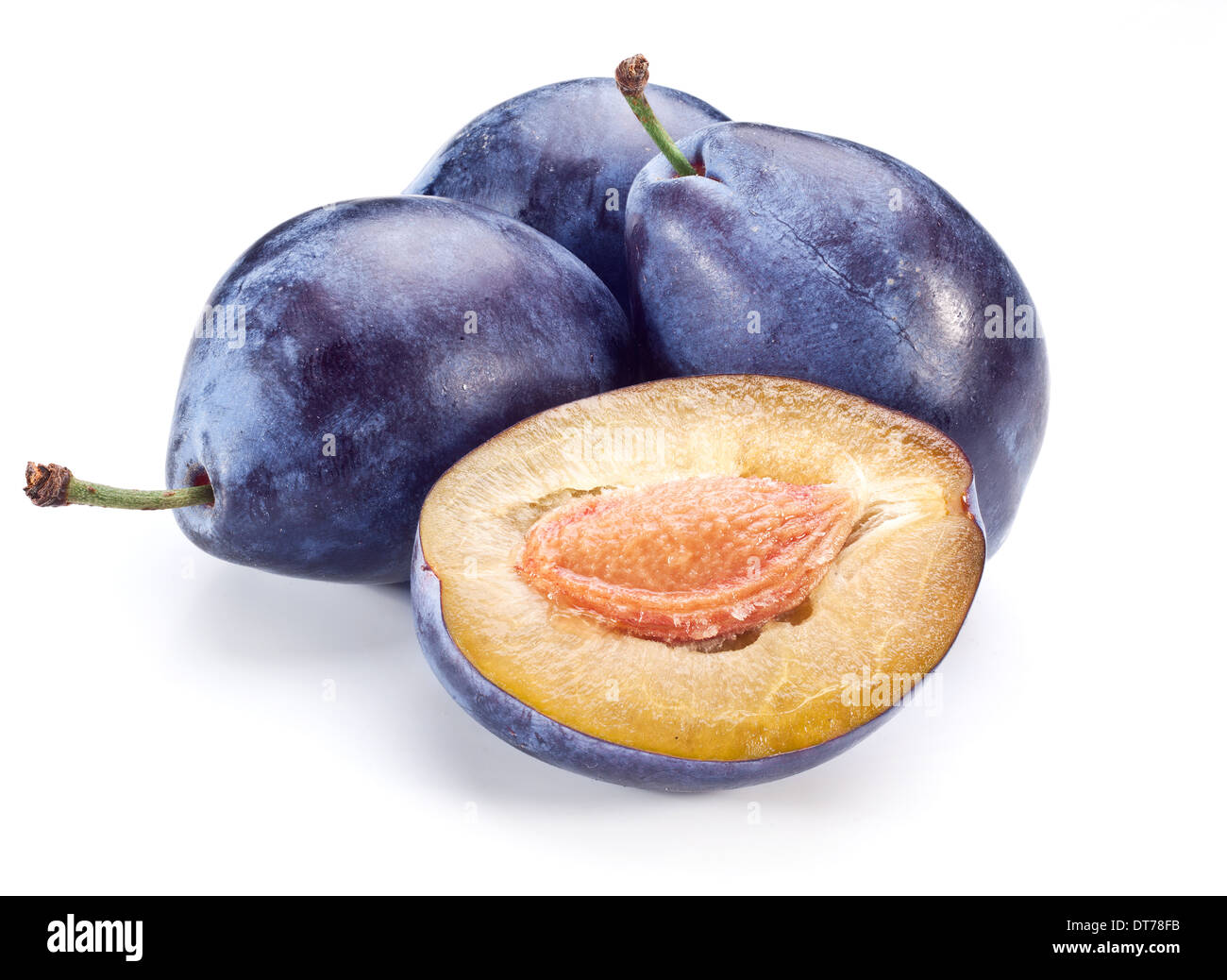 Plums with a half of one isolated on a white background. Stock Photo