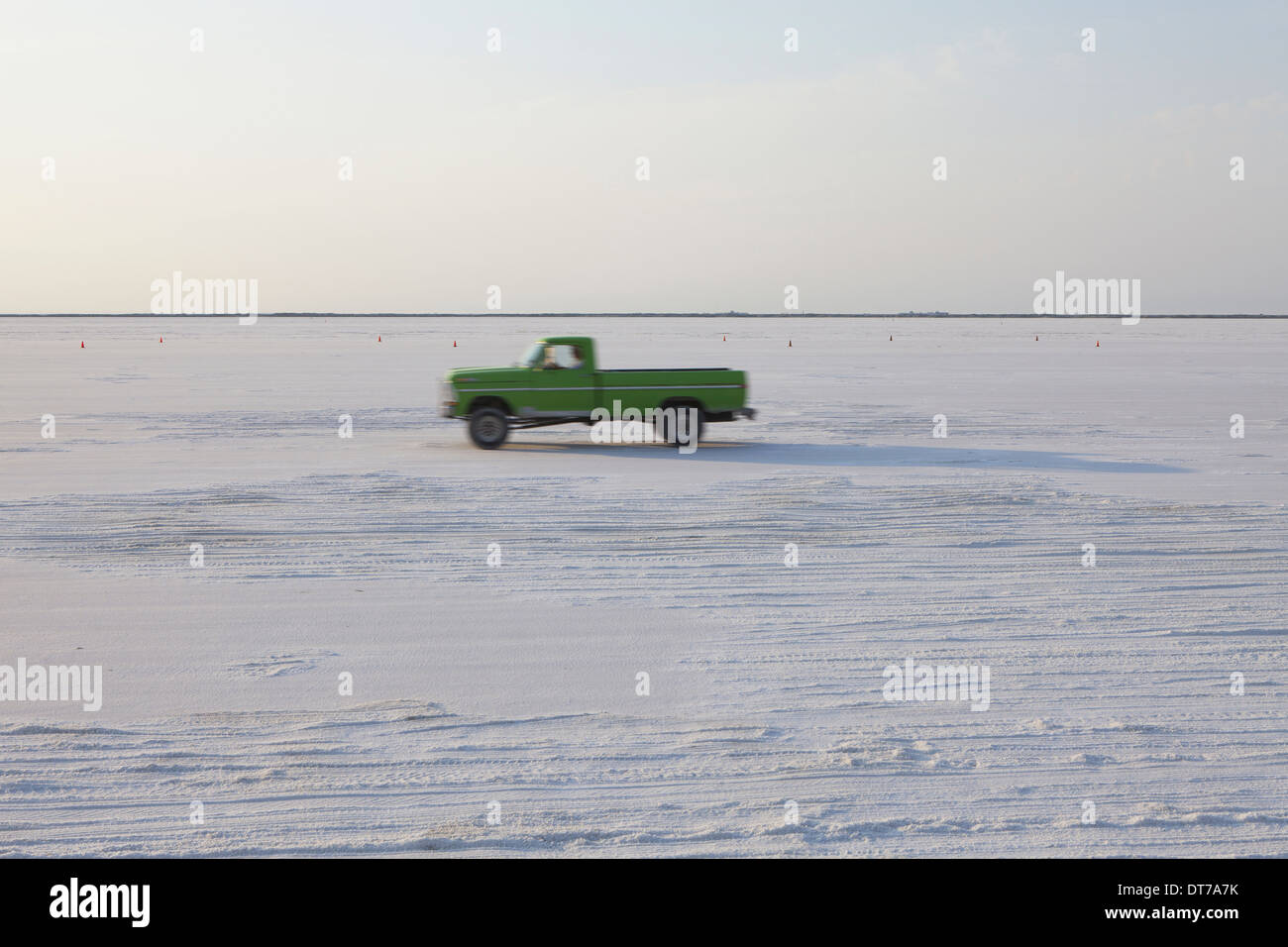 Truck driving on Bonneville Salt Flats during Speed Week dusk