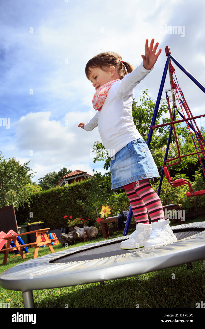 jumping girl on the trampoline in the garden Stock Photo