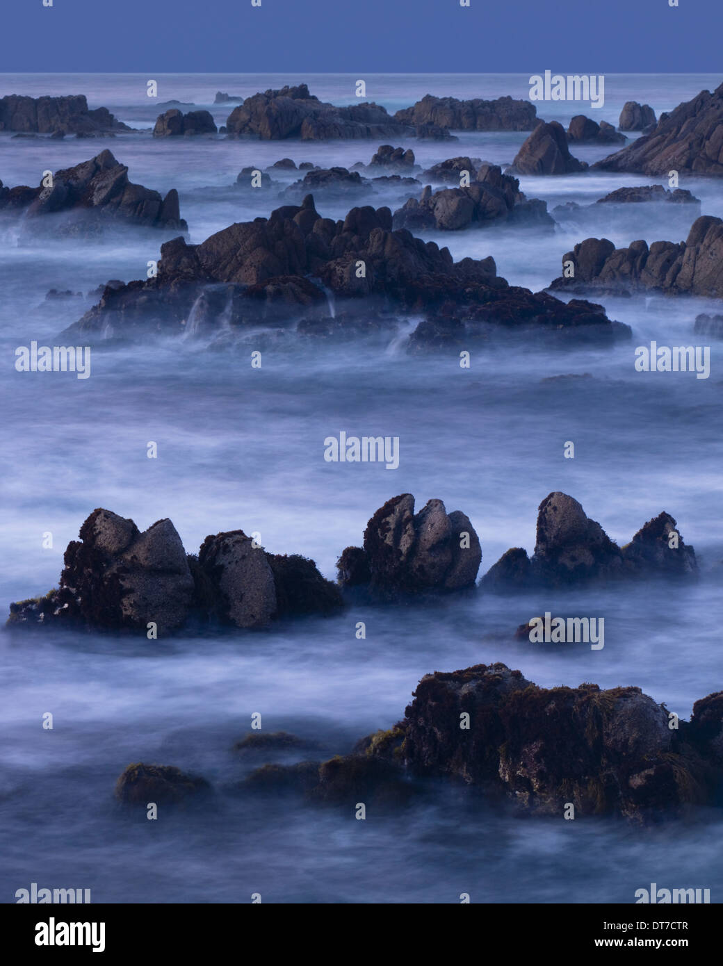 A four minute time exposure of ocean surf and coast rocks Monterey County California USA Stock Photo