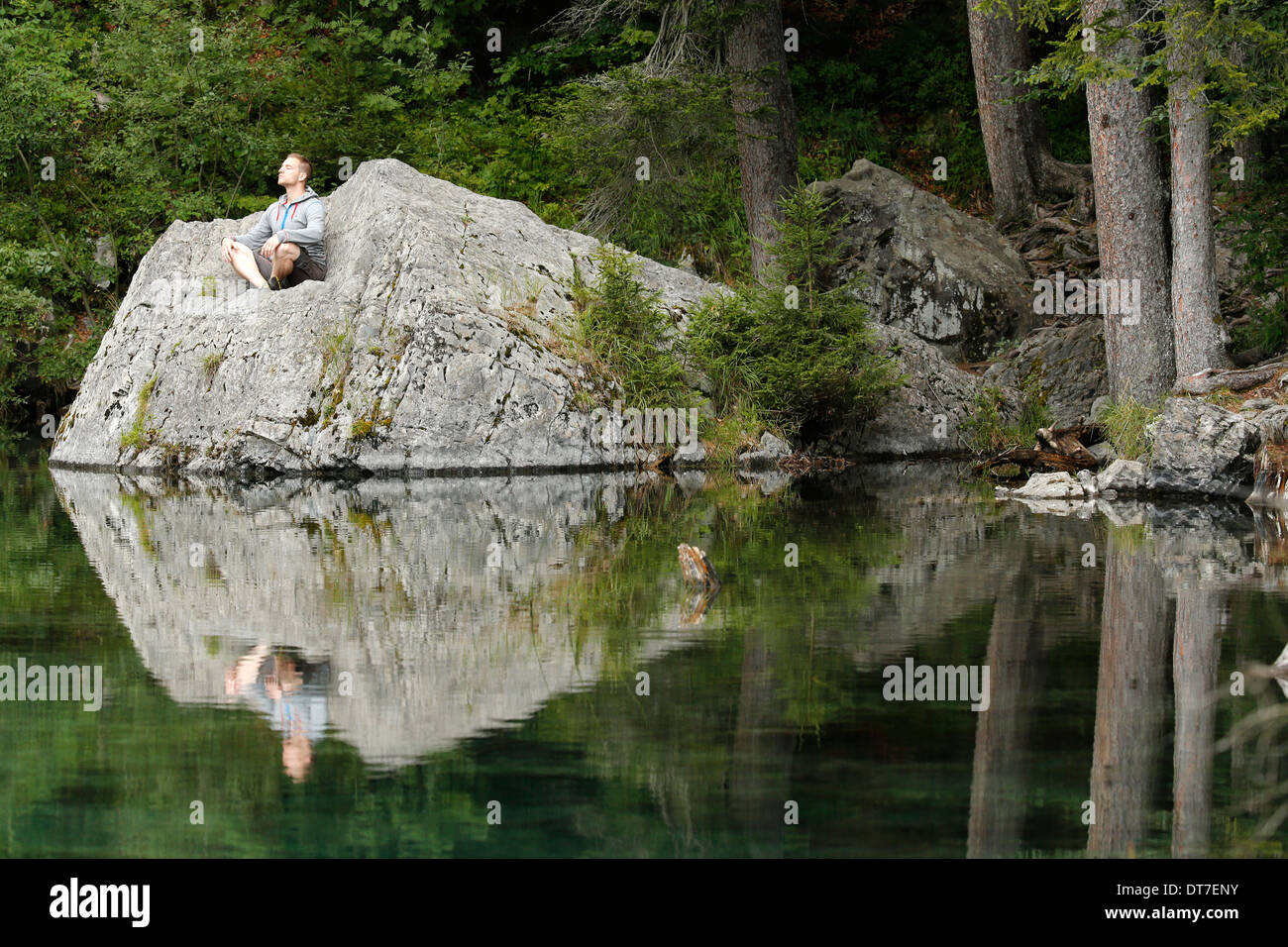 Man praying in front of a lake. Stock Photo