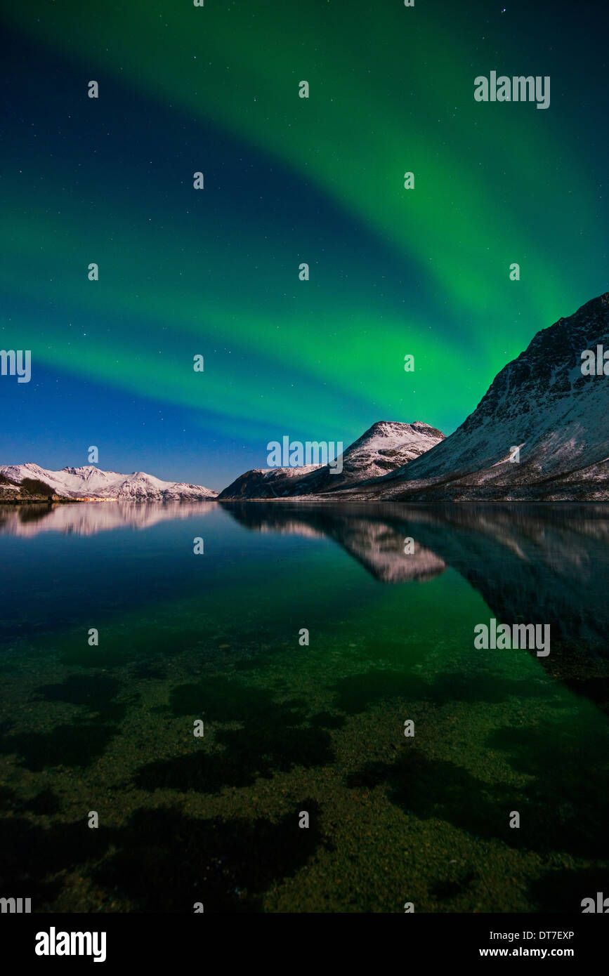 Aurora Borealis reflecting on a fjord in the mountains near Tromso in ...