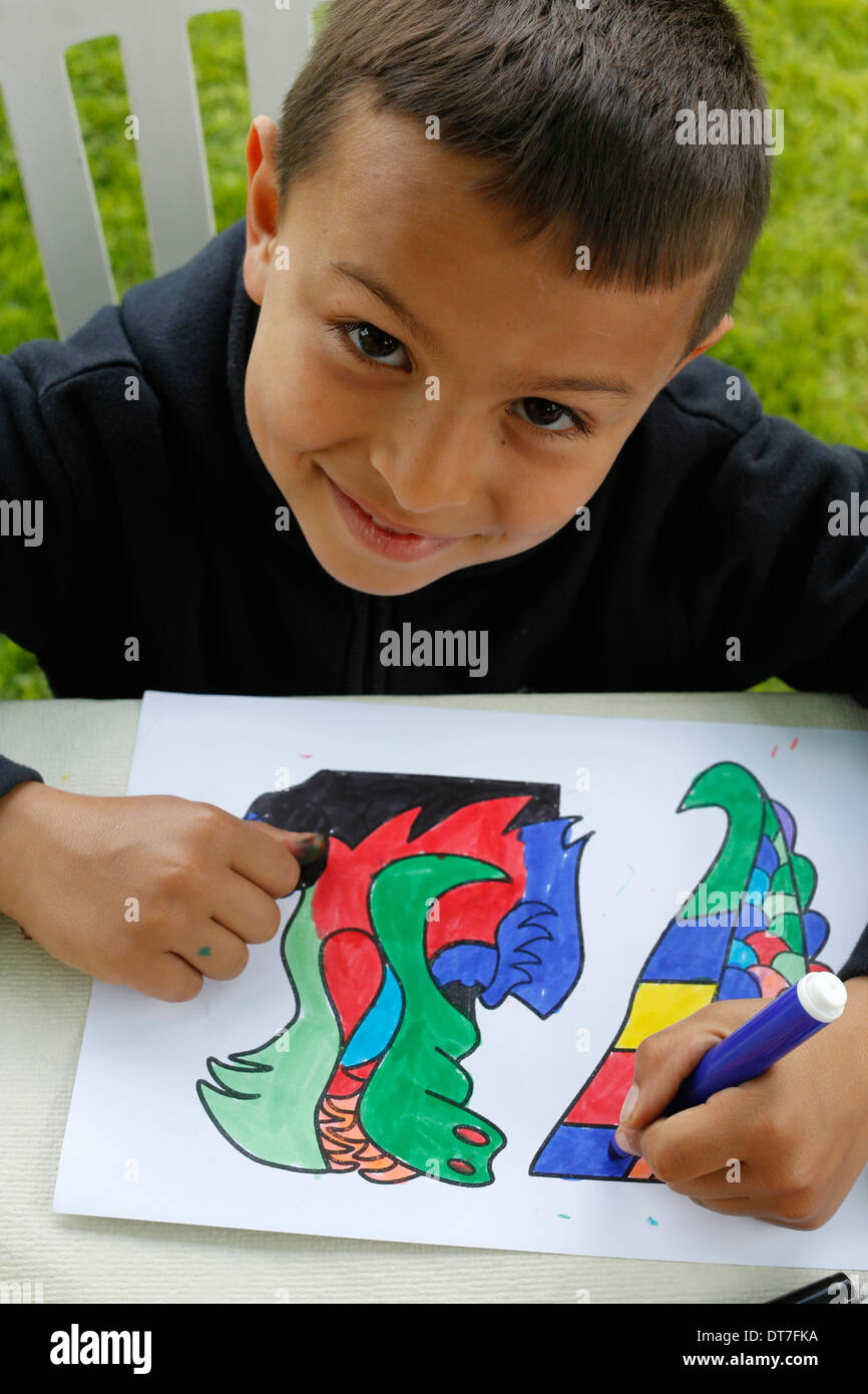 Boy colouring in a drawing Stock Photo