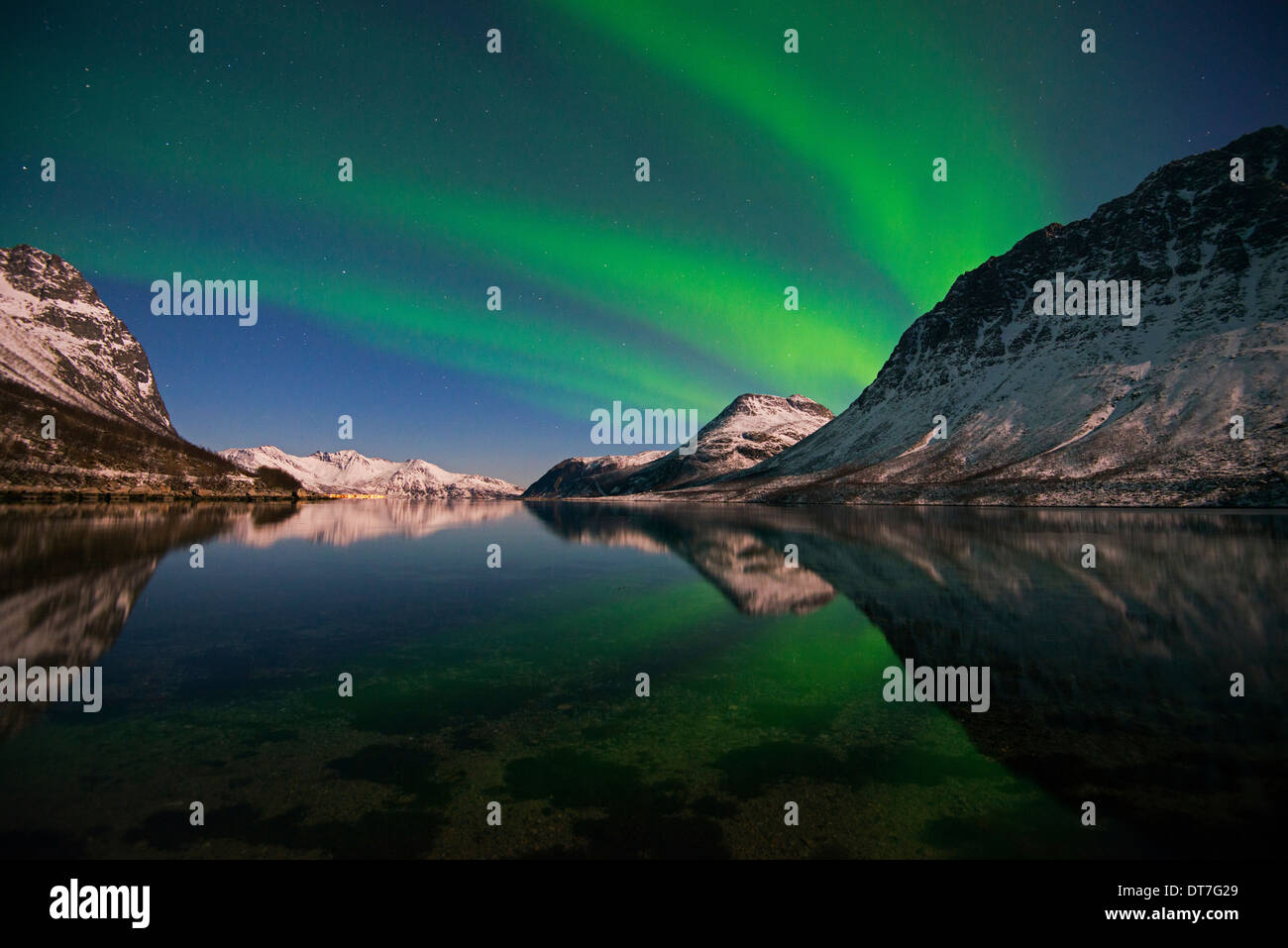 Aurora Borealis reflecting on a fjord in the mountains near Tromso in ...