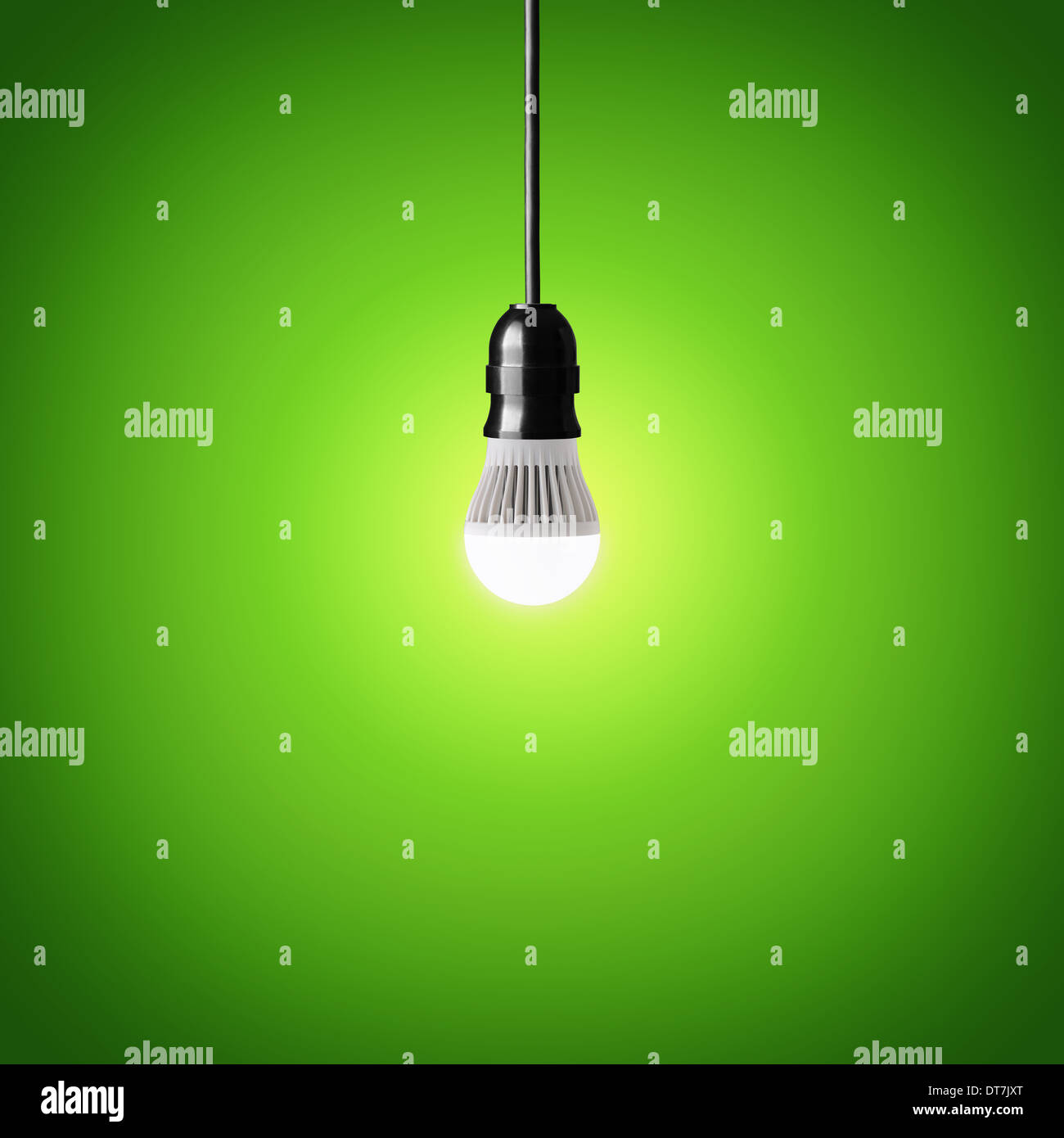 Glowing led bulb on green background Stock Photo