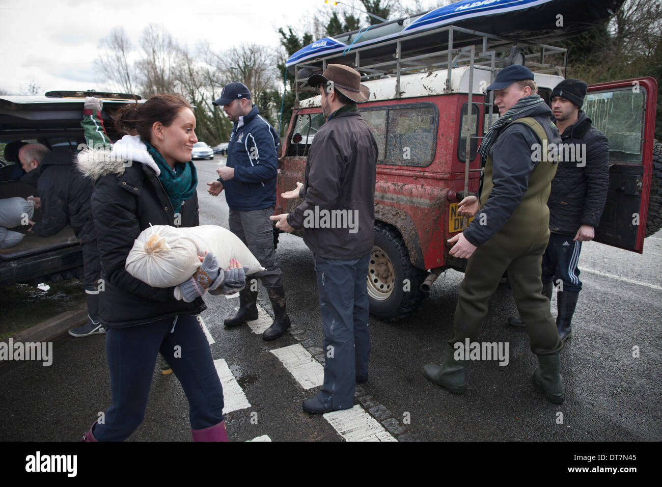 Wraysbury, Staines, Berkshire, UK. 11th Feb, 2014. Picture shows people in Gloucster Drive carrying sand bags to protect their homes in Wraysbury near Staines in the Thames Valley area West of London. Hundreds of families are having to leave their houses due to the rising water levels across the region. Credit:  Jeff Gilbert/Alamy Live News Stock Photo