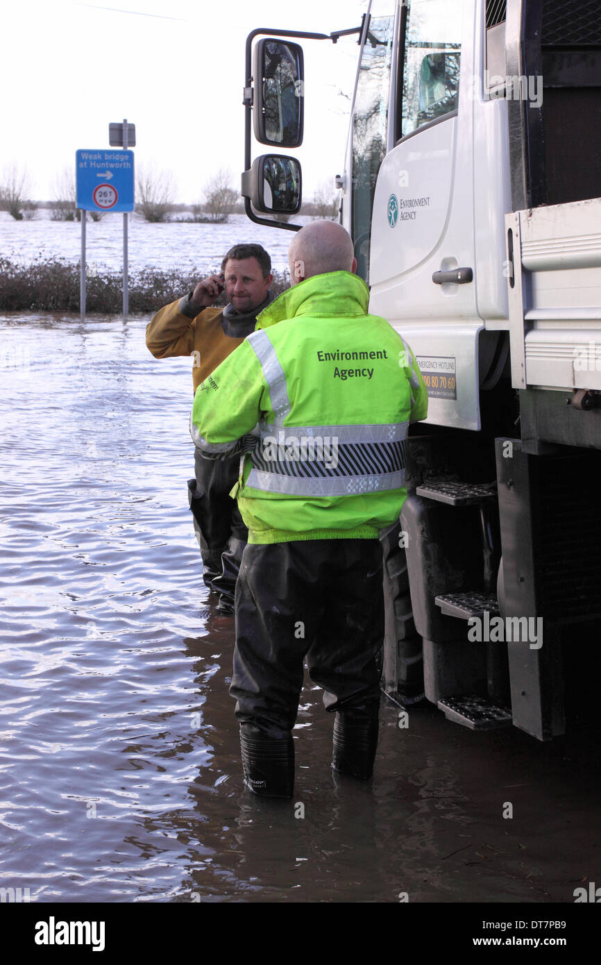 Burrowbridge, Somerset Levels, UK – 11th February 2014. Staff from the Environment Agency await their next deployment at the flooded A361 road. Stock Photo