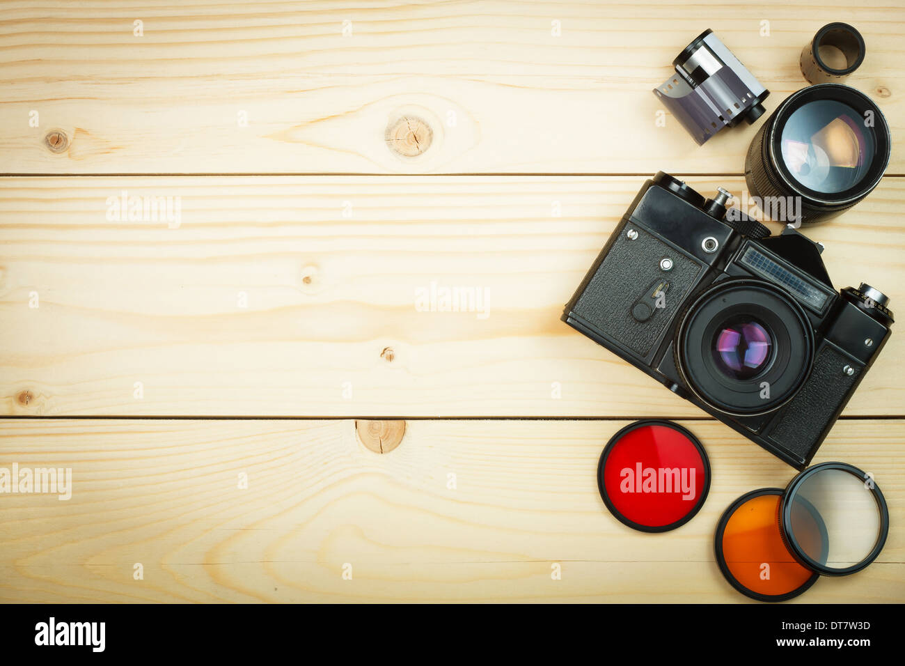 Old retro camera and film roll on wooden boards. Empty space on your text Stock Photo