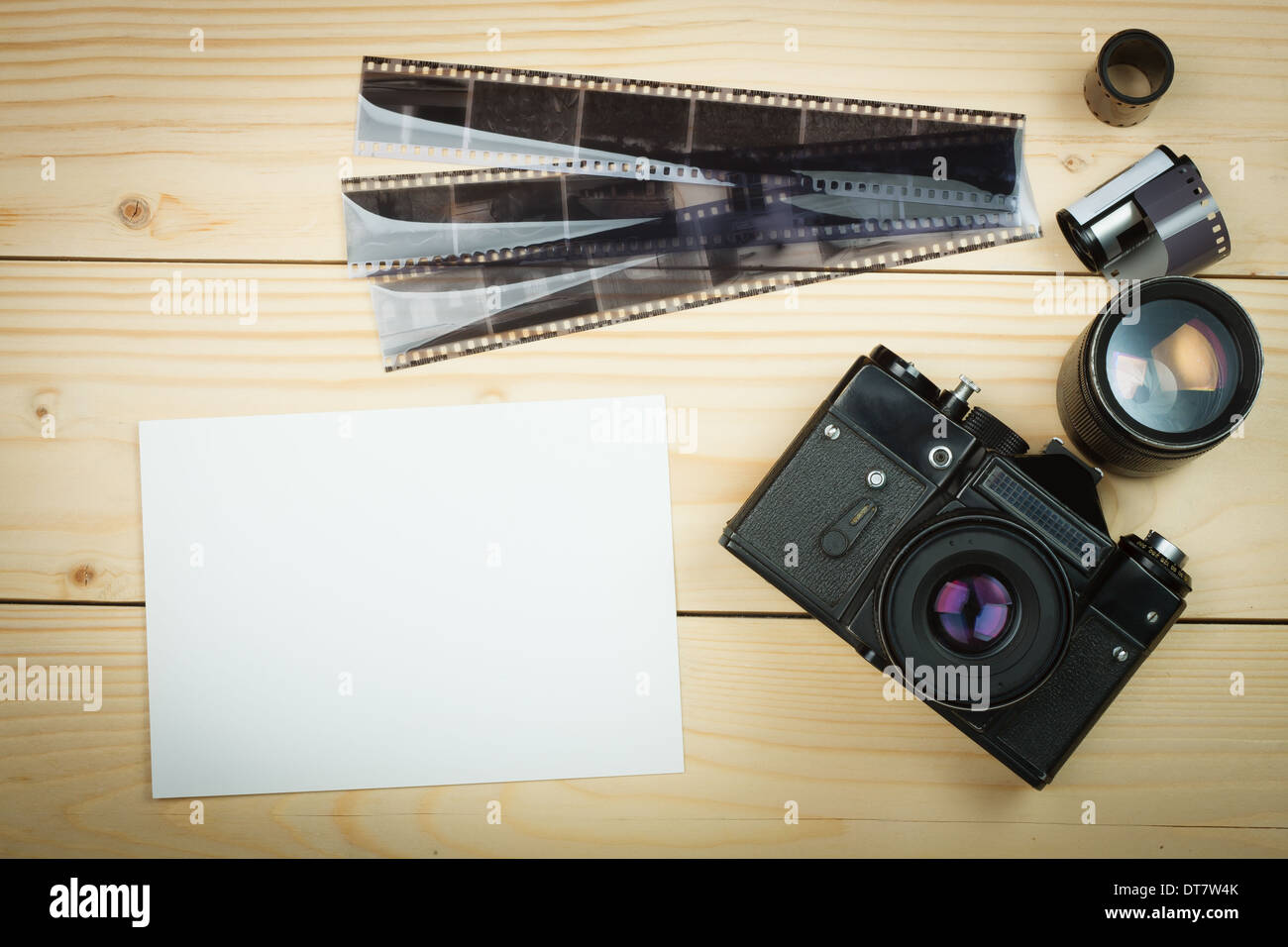 Old retro camera and film roll on wooden boards. Stock Photo