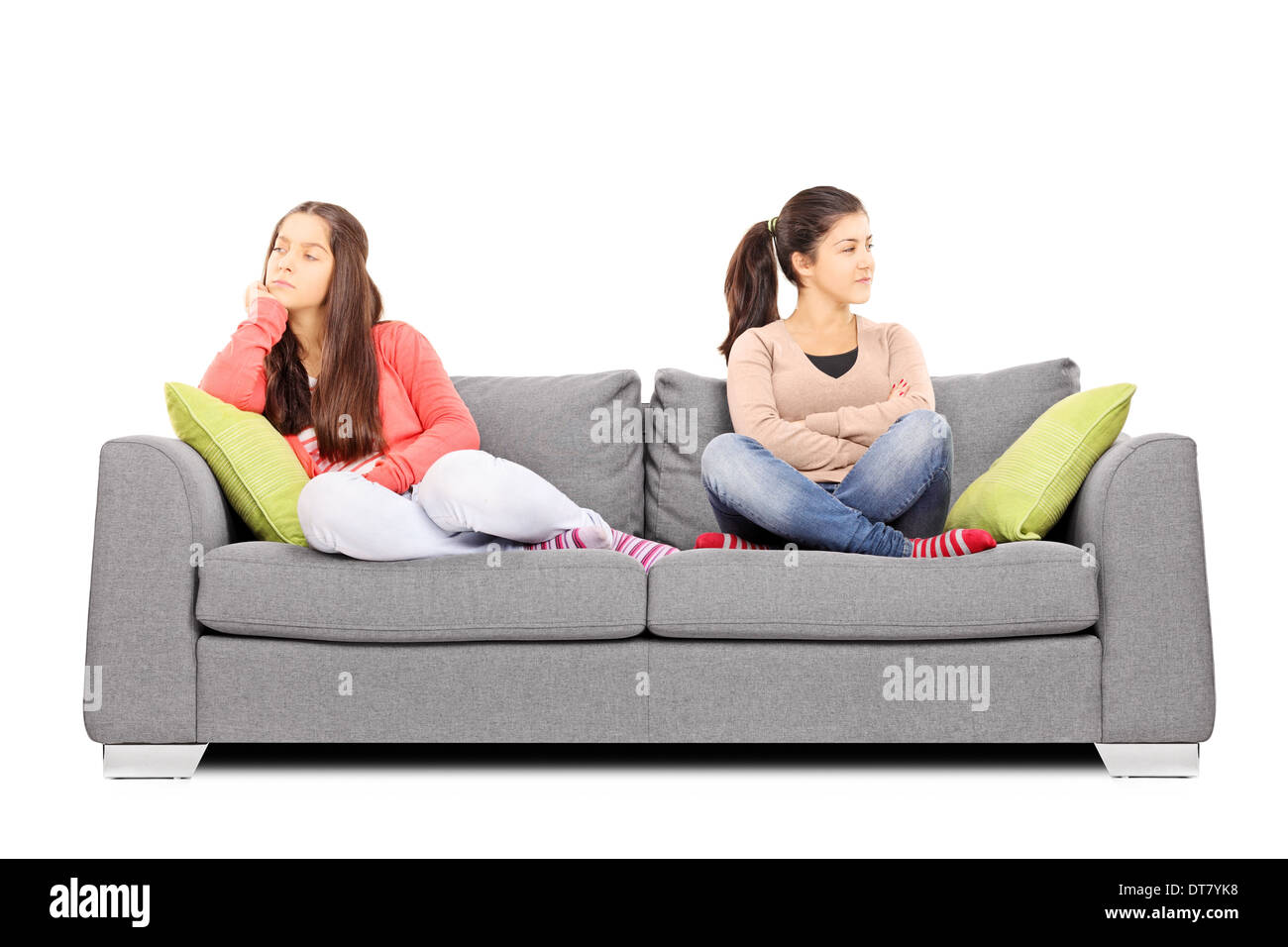 Two teenage girls sitting on sofa angry with each other Stock Photo