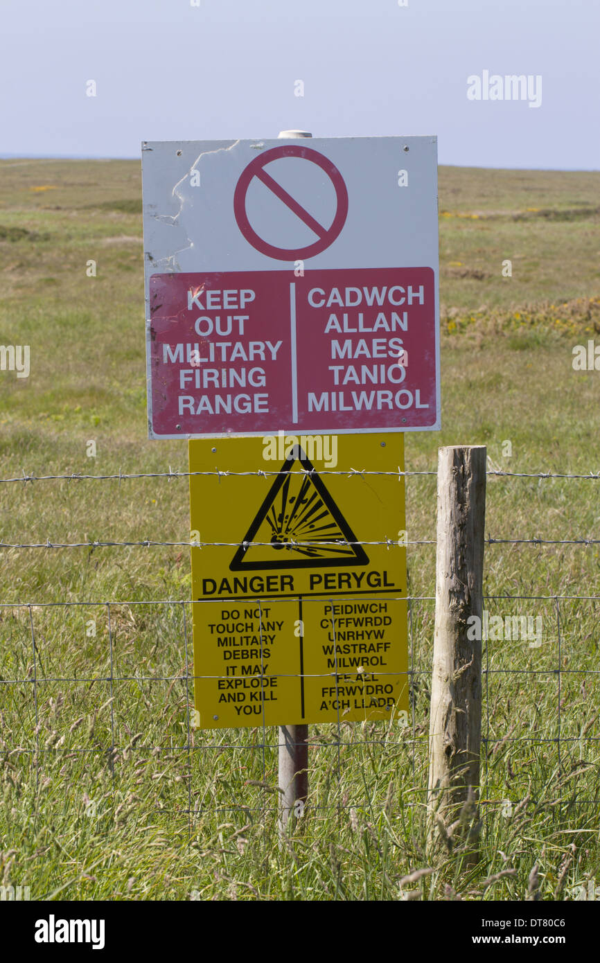 Keep Out Military Firing Range' and 'Danger' bilingual signs at coastal military firing range Castlemartin Range Pembrokeshire Stock Photo