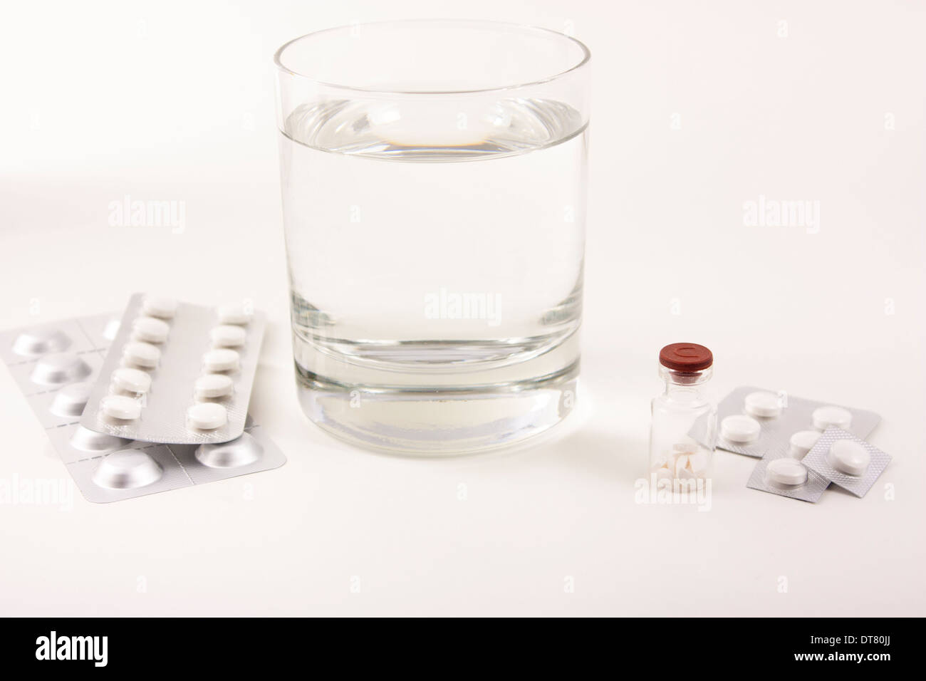Glass with water and tablets, pills on a white background Stock Photo