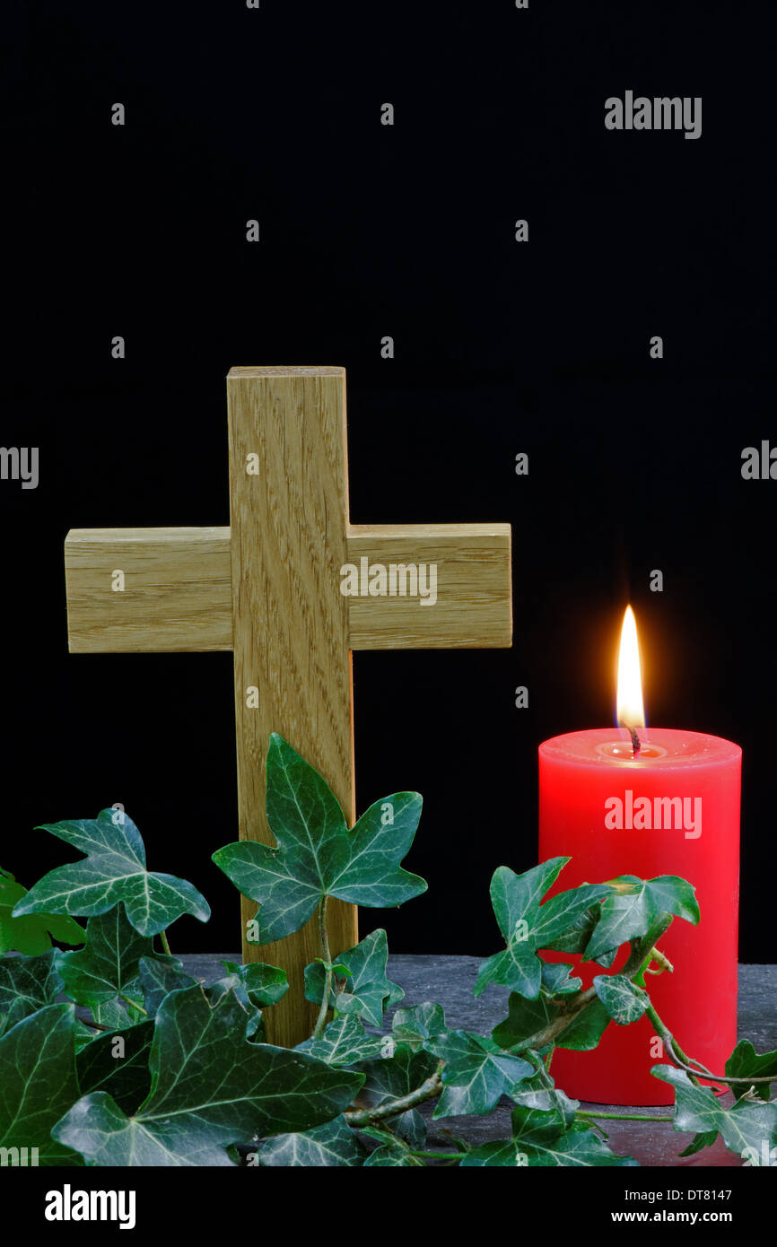 Candle and cross on slate with ivy. Holy symbols for Christian