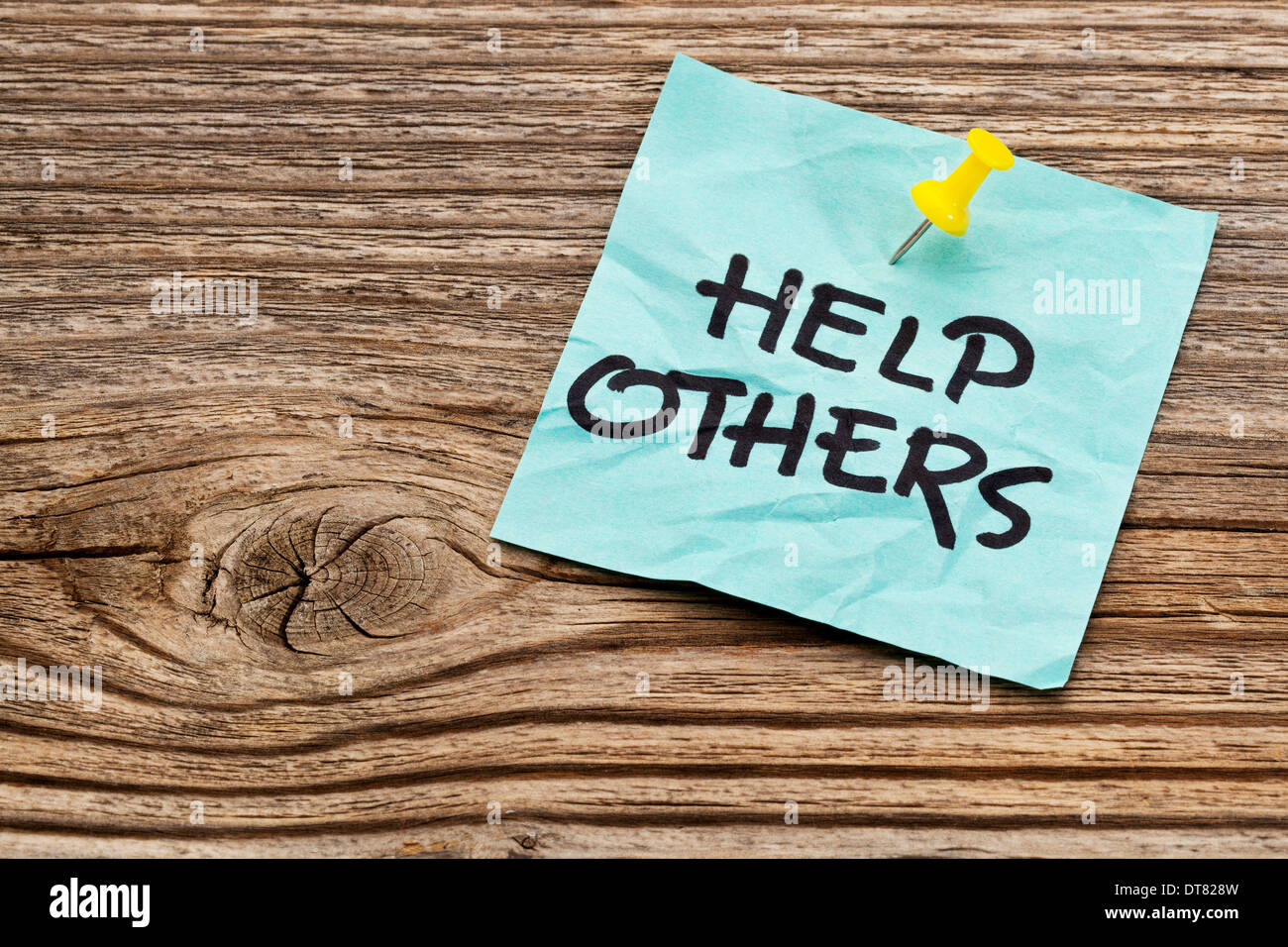 help others reminder note against grained weathered wood Stock Photo