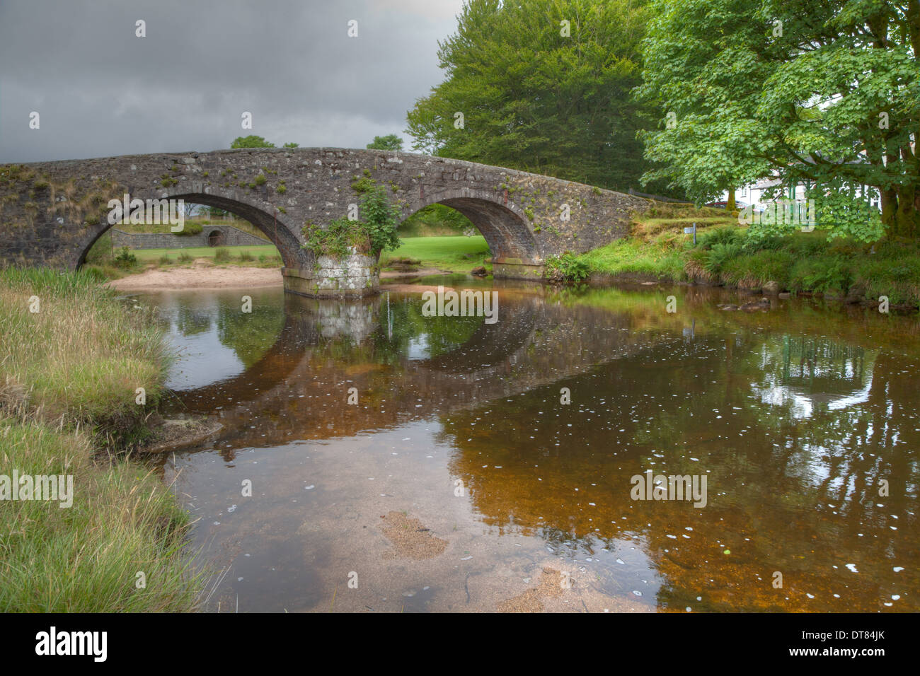 The Sedate flow of the West Dart under the 'Old Bridge' at Two Bridges on Dartmoor. Stock Photo